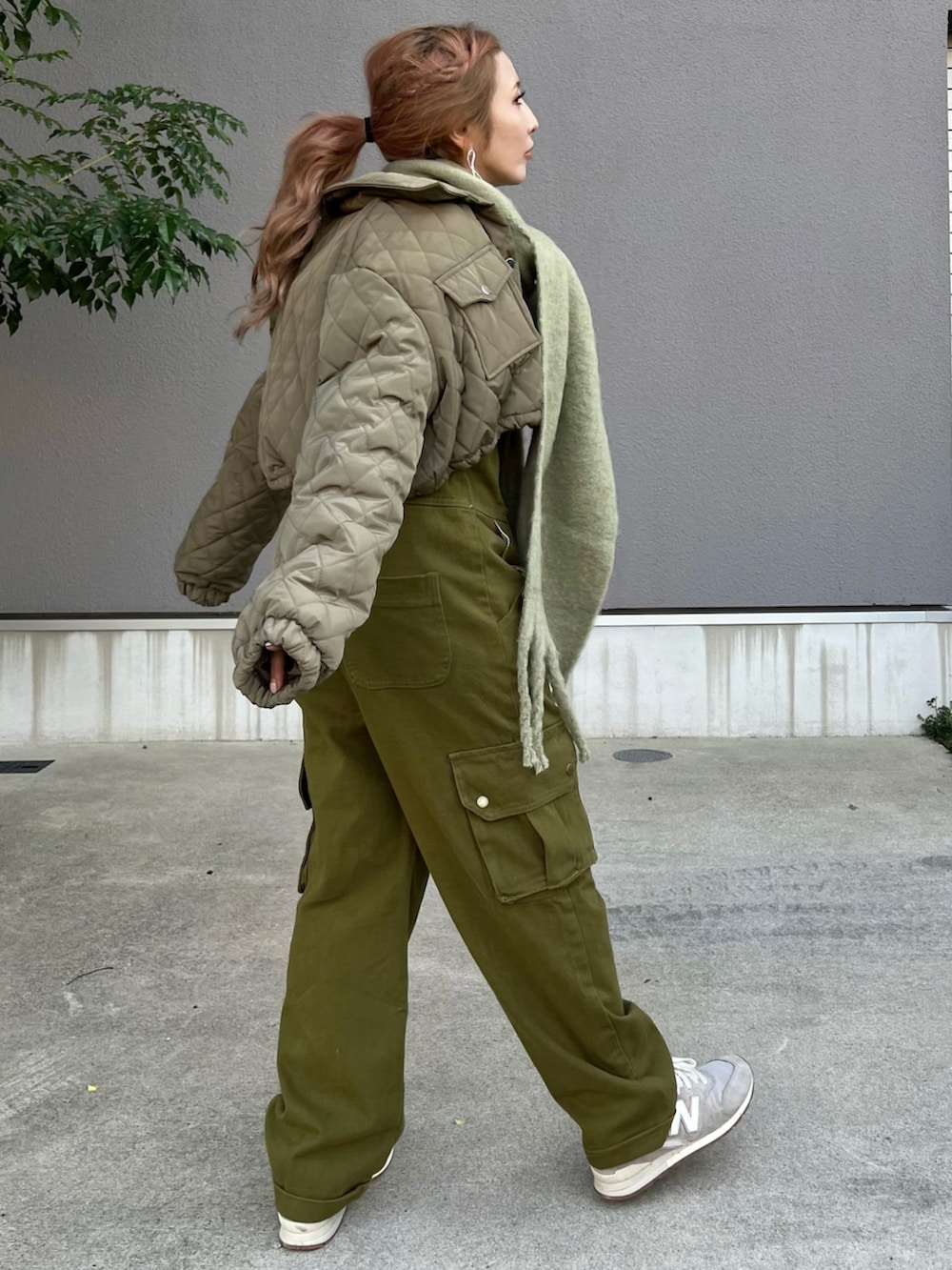 グリーン系のサロペット/オーバーオール、グレー系のスニーカー、グレー系のパーカーを着用したレディースの秋コーディネートの4枚目の写真