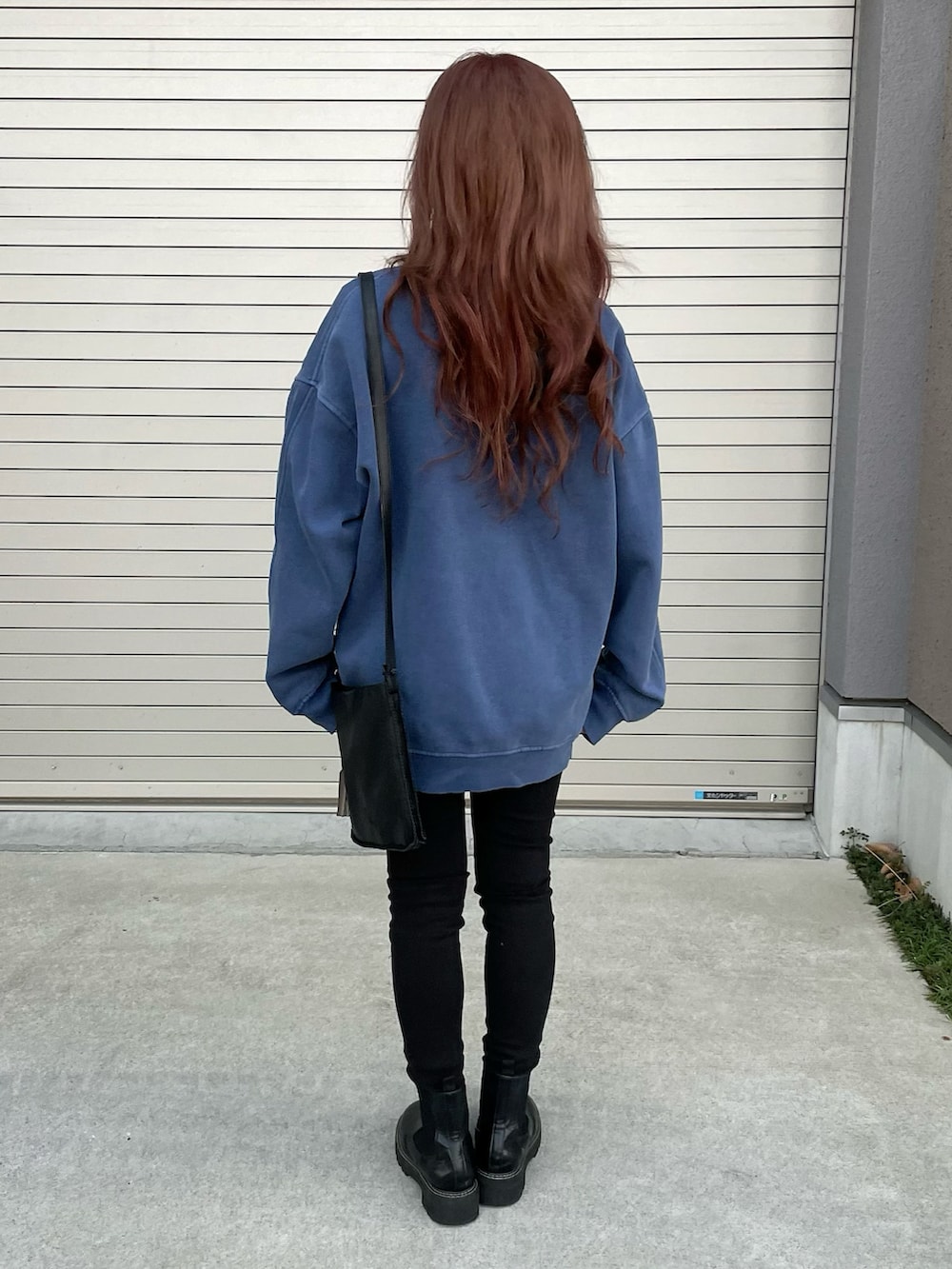 ブルー系のスウェット、ブラック系のデニムパンツ、ブラック系のデニムパンツを着用したレディースの冬コーディネートの3枚目の写真