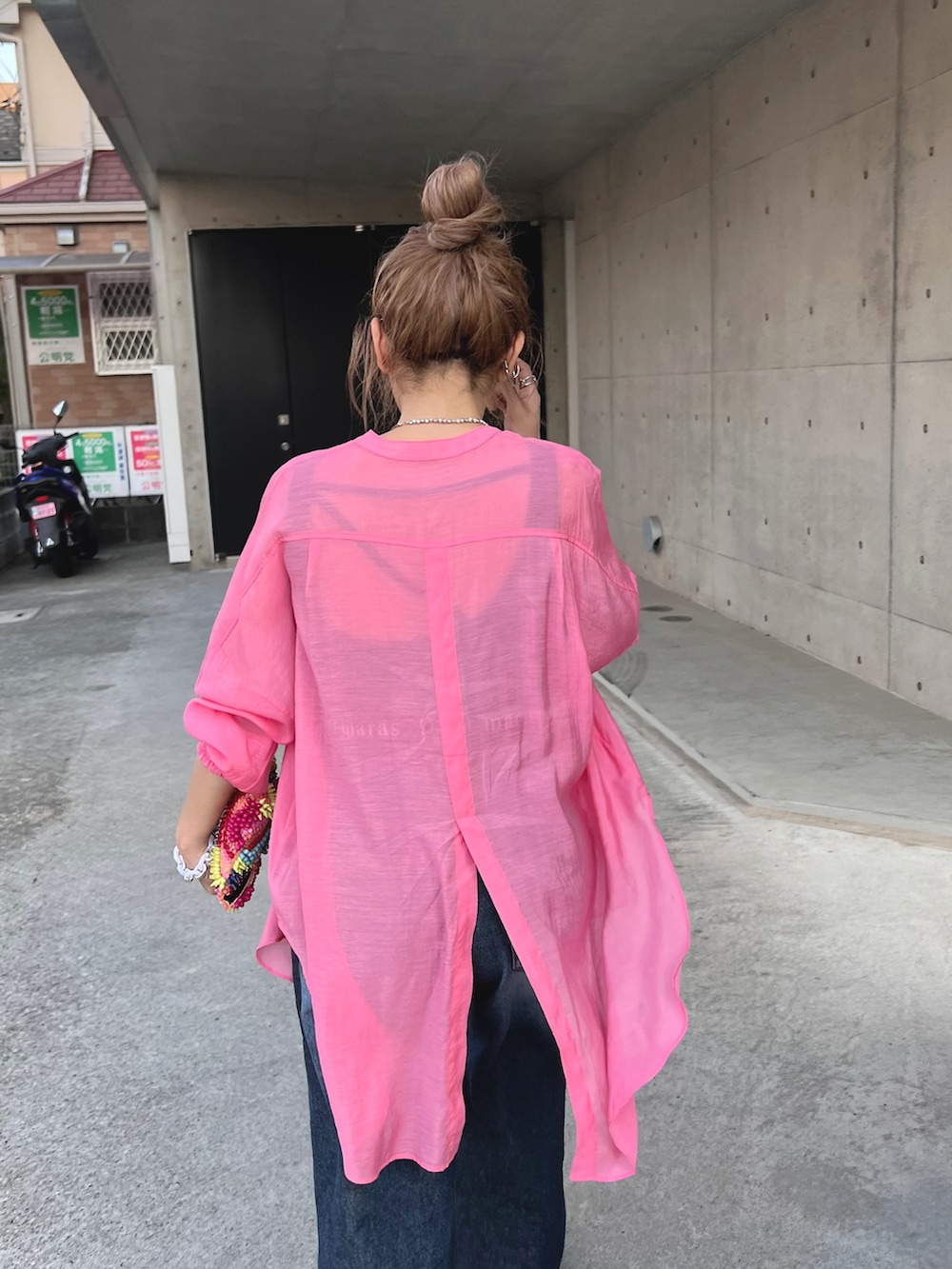 ブルー系のデニムパンツ、ホワイト系のスニーカー、ピンク系のシャツ/ブラウスを着用したレディースの春コーディネートの4枚目の写真