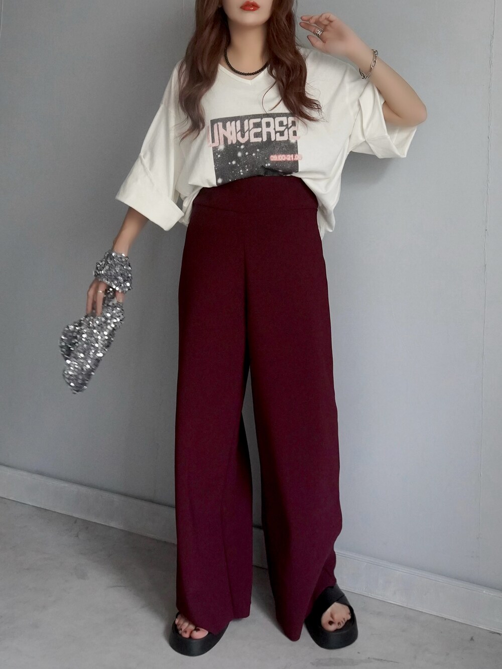 ブラック系のバッグ、レッド系のパンツ、ホワイト系のチュニックを着用したレディースの春コーディネートの5枚目の写真