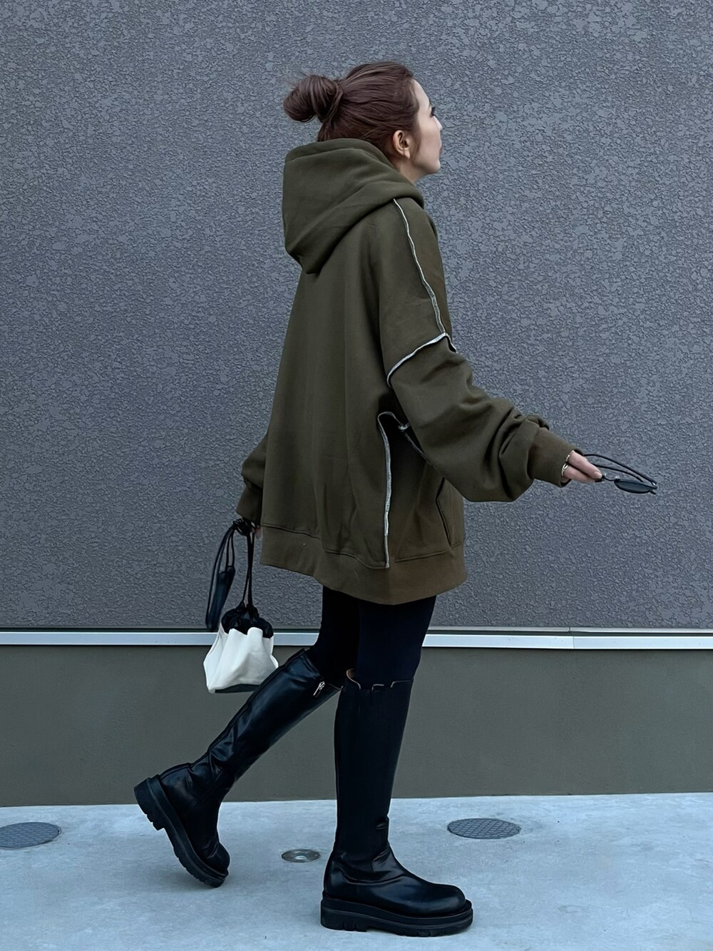 ブラック系のパーカー、ブラック系のその他パンツ、ブラック系のブーツを着用したレディースの秋コーディネートの3枚目の写真