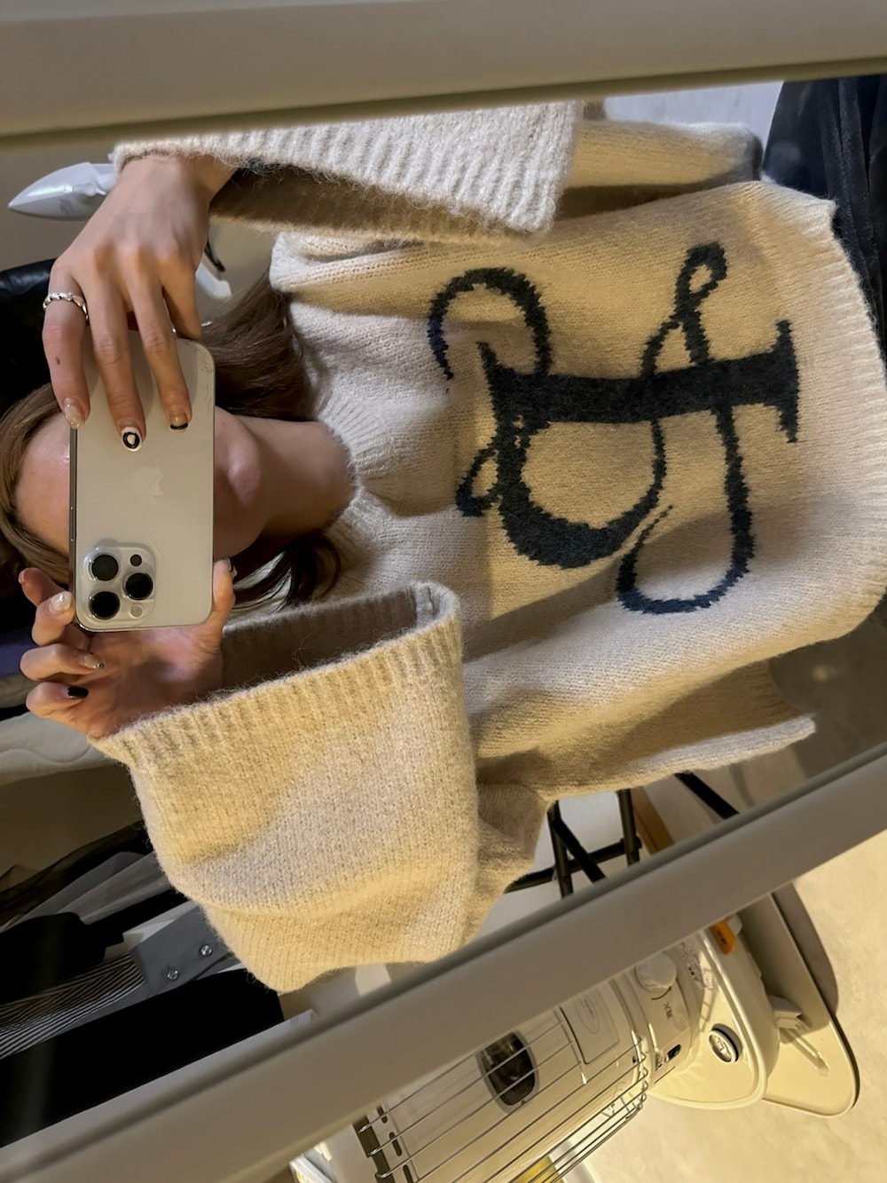 ブルー系のデニムパンツ、ベージュ系のニット/セーター、ブルー系のデニムパンツを着用したレディースの冬コーディネートの3枚目の写真