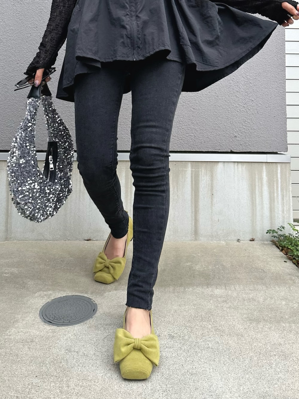 ブラック系のベスト、ブラック系のトップス、ブラック系のデニムパンツを着用したレディースの秋コーディネートの5枚目の写真