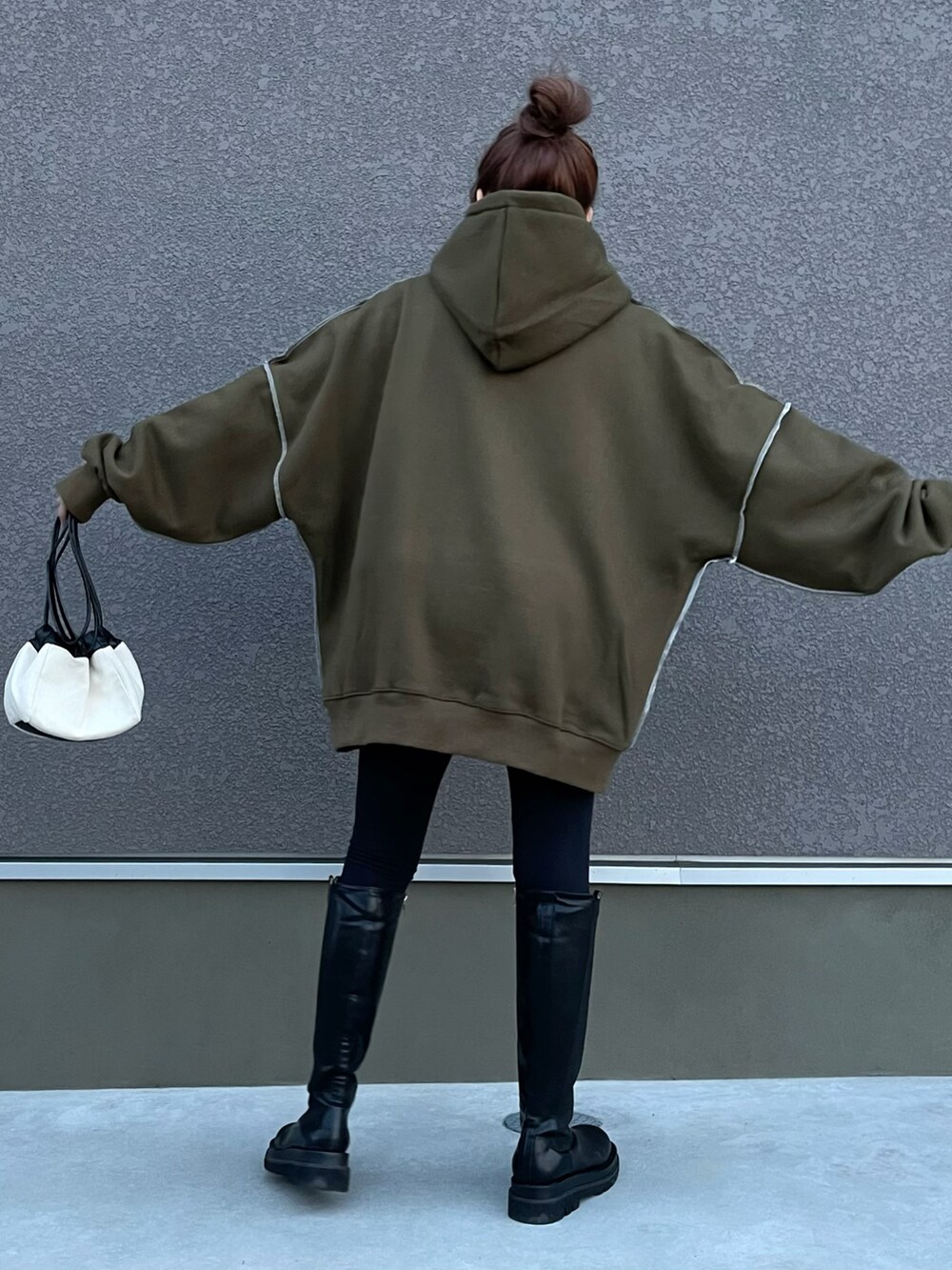 ブラック系のパーカー、ブラック系のその他パンツ、ブラック系のブーツを着用したレディースの秋コーディネートの4枚目の写真