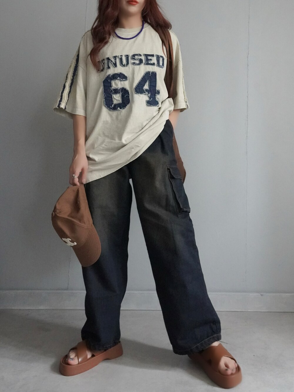 ブルー系のデニムパンツ、ベージュ系のTシャツ/カットソーを着用したレディースの春コーディネートの2枚目の写真