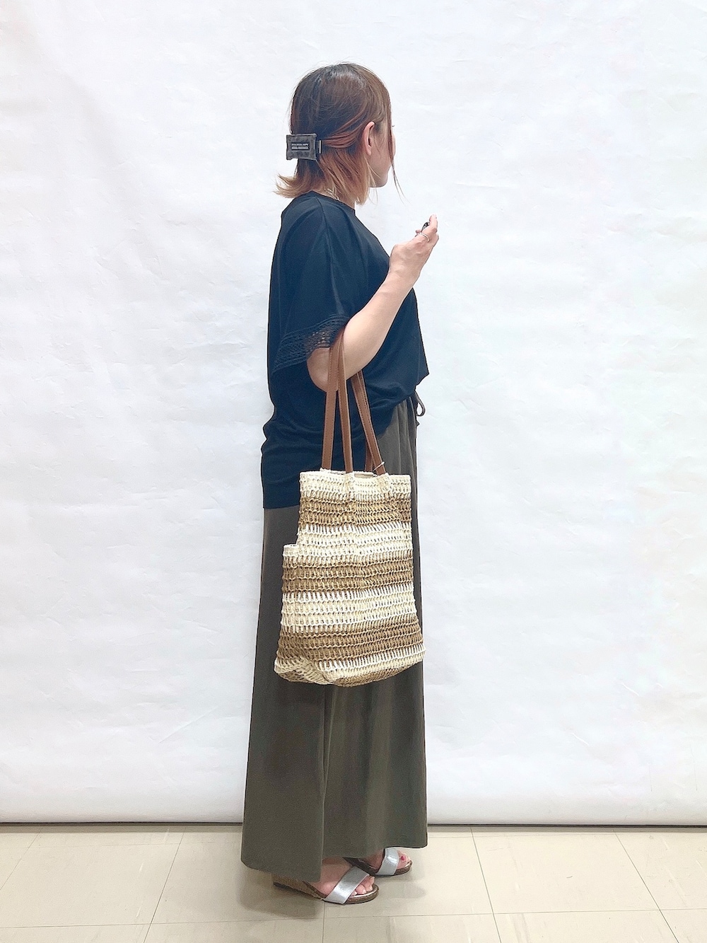 ブラック系のTシャツ/カットソー、グリーン系のスカート、シルバー系のサンダルを着用したレディースの夏コーディネートの2枚目の写真