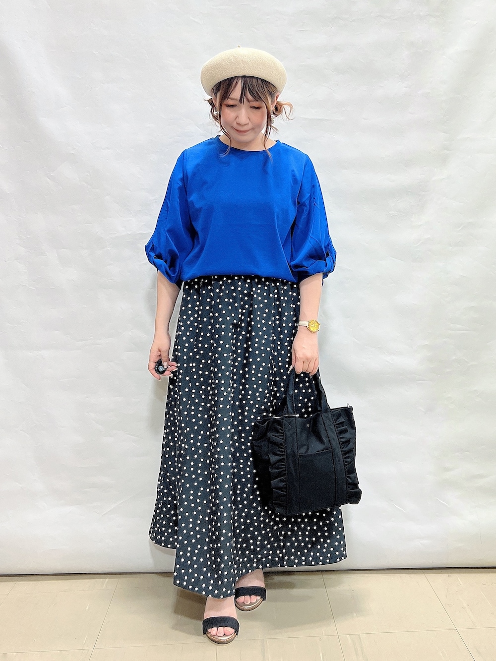 ブルー系のTシャツ/カットソー、ブラック系のスカート、ブラック系のサンダルを着用したレディースの夏コーディネートの4枚目の写真