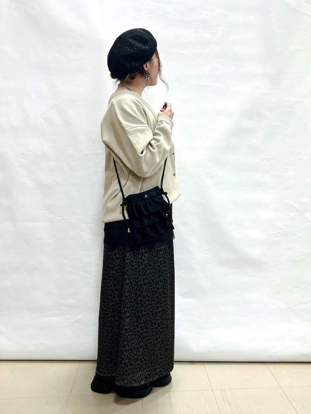 ベージュ系のカーディガン/ボレロ、ブラック系のタンクトップ、グレー系のスカートを着用したレディースの秋コーディネートの2枚目の写真