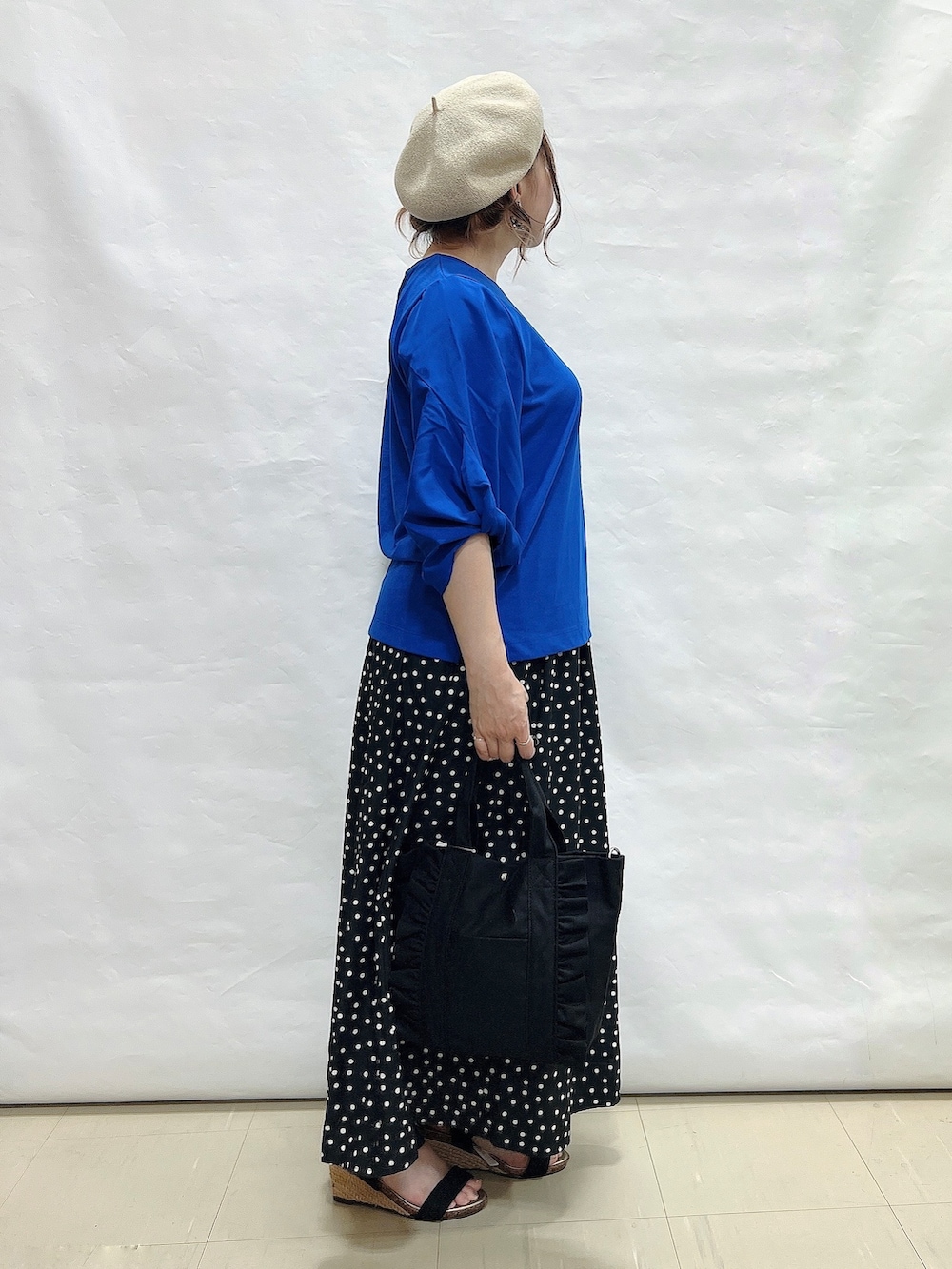 ブルー系のTシャツ/カットソー、ブラック系のスカート、ブラック系のサンダルを着用したレディースの夏コーディネートの2枚目の写真