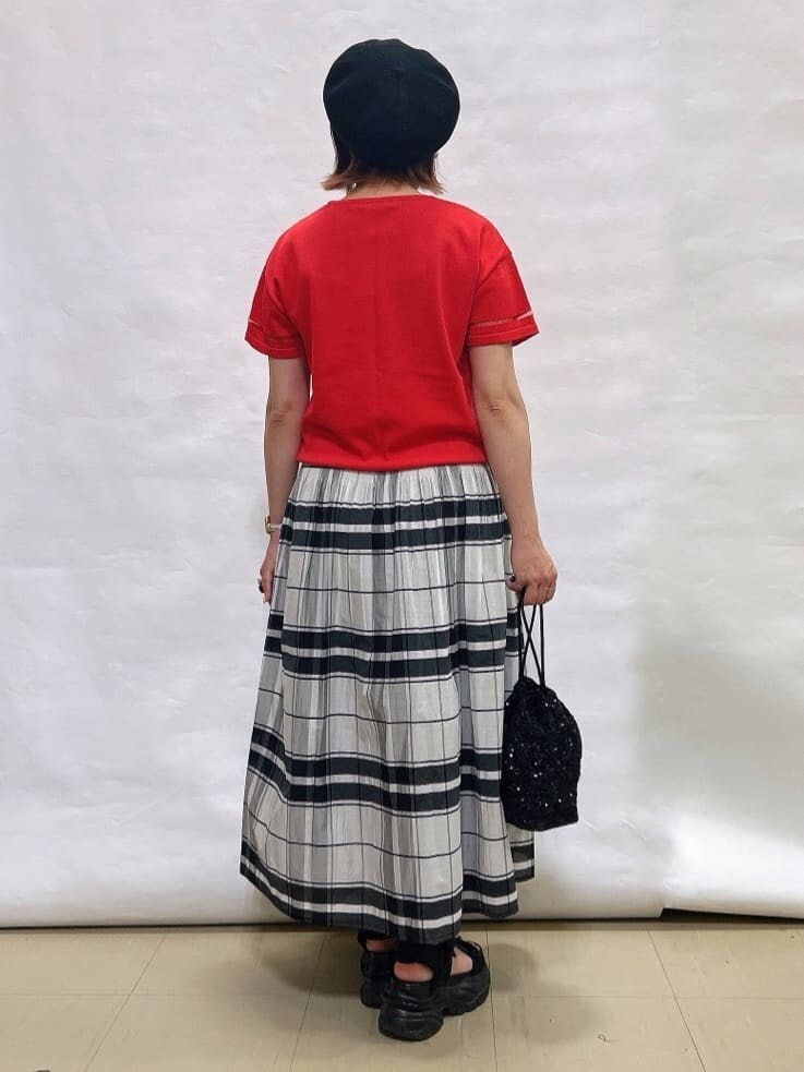 ピンク系のニット/セーター、ホワイト系のスカート、ブラック系のショルダーバッグを着用したレディースの夏コーディネートの3枚目の写真