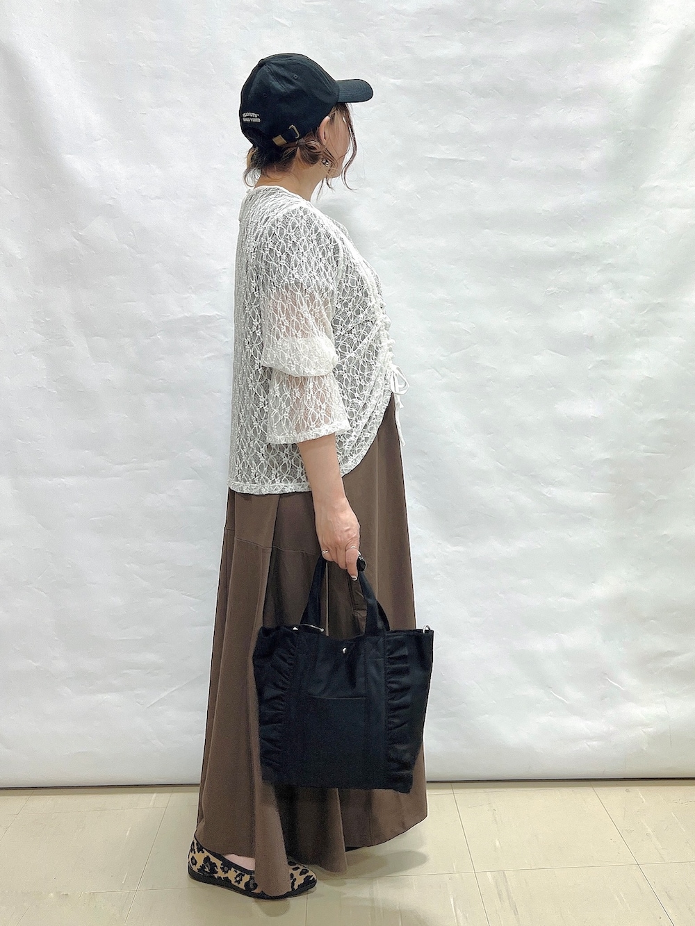 ブラウン系のワンピース、ホワイト系のTシャツ/カットソー、ブラウン系のパンプスを着用したレディースの夏コーディネートの2枚目の写真