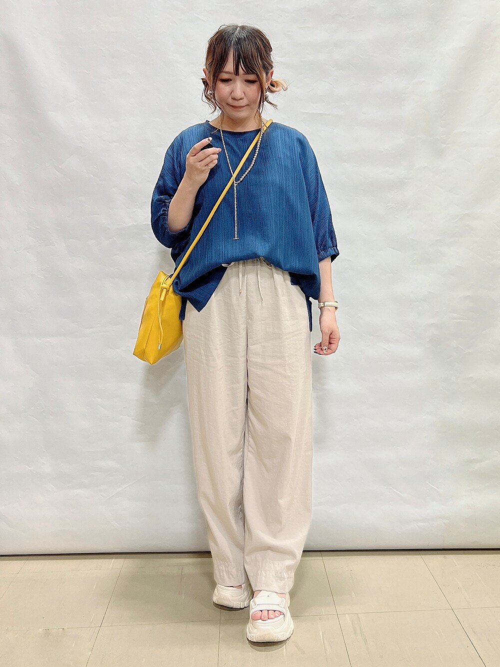 ブルー系のシャツ/ブラウス、ベージュ系のその他パンツ、イエロー系のショルダーバッグを着用したレディースの夏コーディネートの4枚目の写真