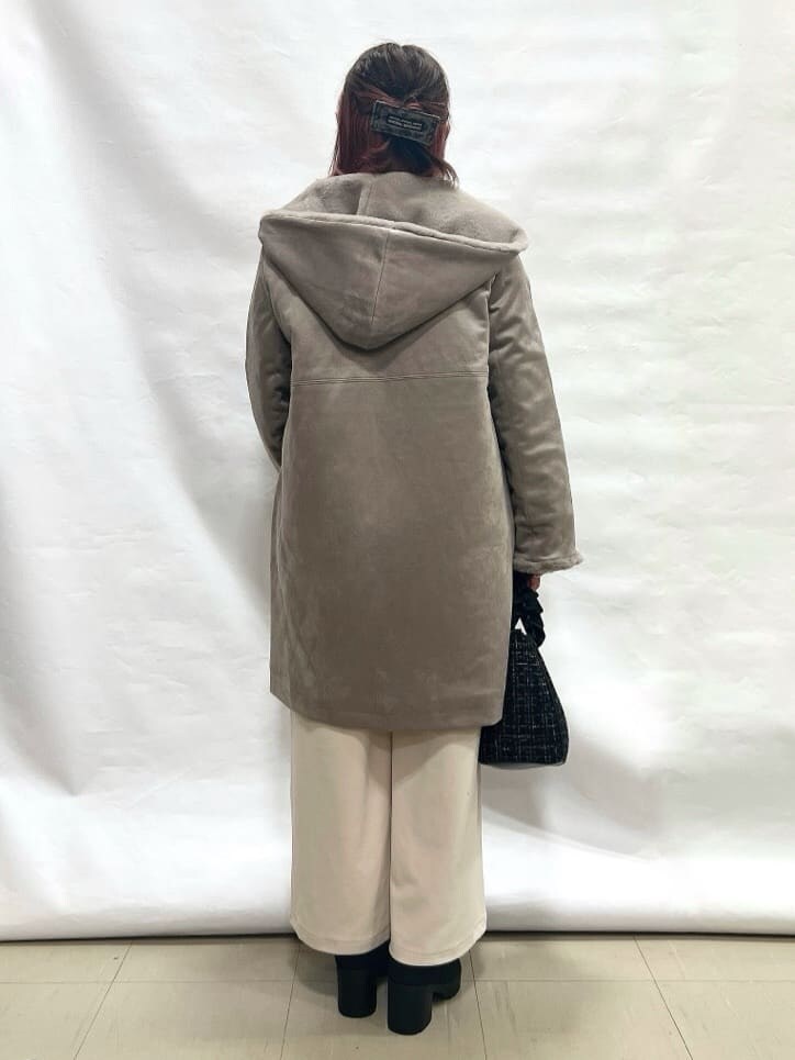 ブラウン系のその他アウター、レッド系のニット/セーター、ホワイト系のその他パンツを着用したレディースの冬コーディネートの3枚目の写真