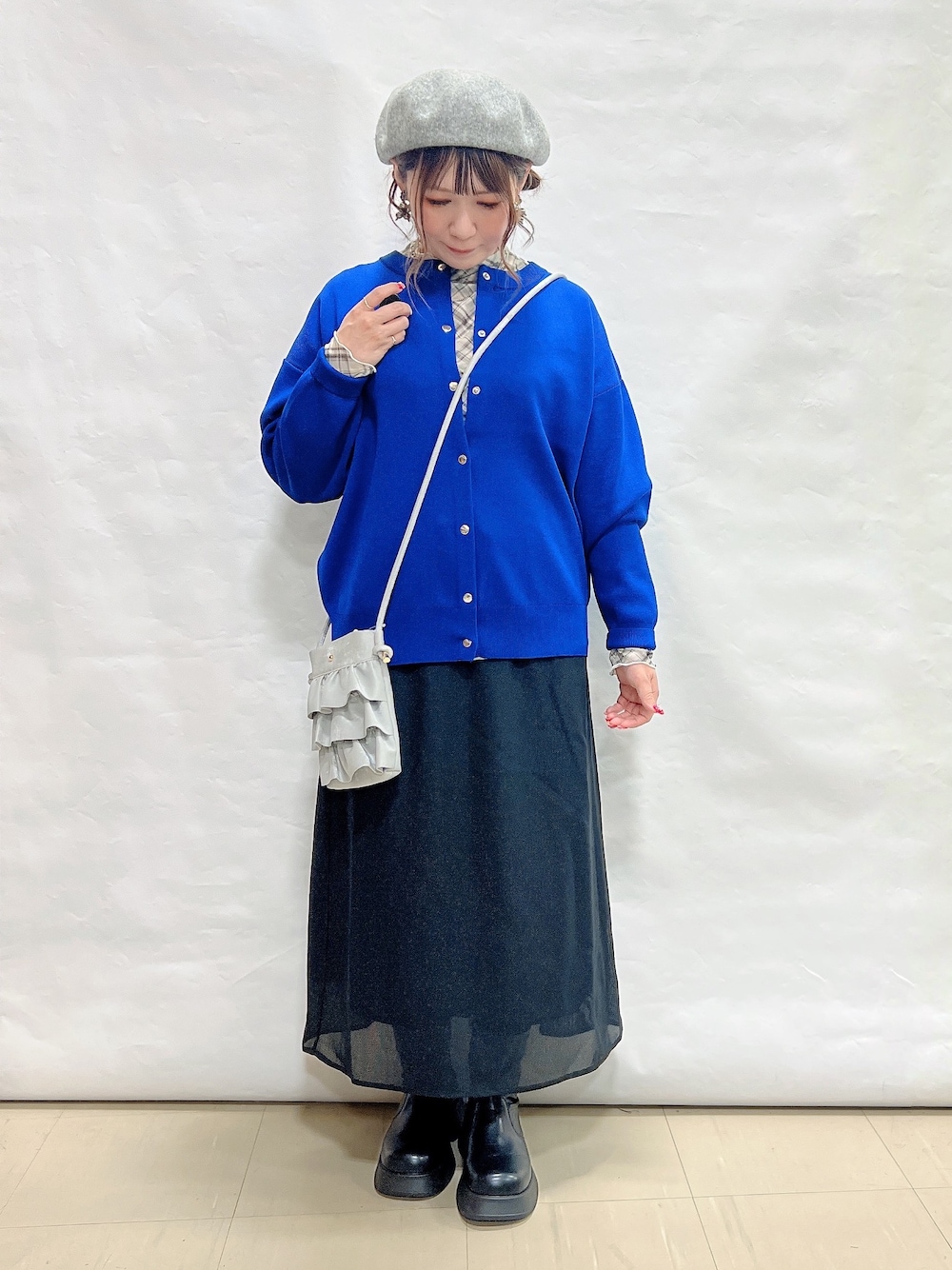 ブルー系のカーディガン/ボレロ、グレー系のTシャツ/カットソー、ブラック系のスカートを着用したレディースの秋コーディネートの4枚目の写真