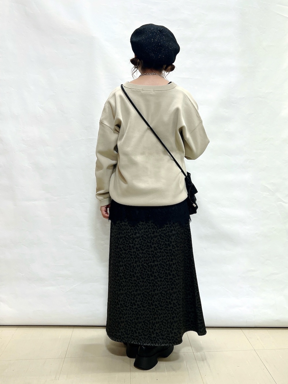 ベージュ系のカーディガン/ボレロ、ブラック系のタンクトップ、グレー系のスカートを着用したレディースの秋コーディネートの3枚目の写真