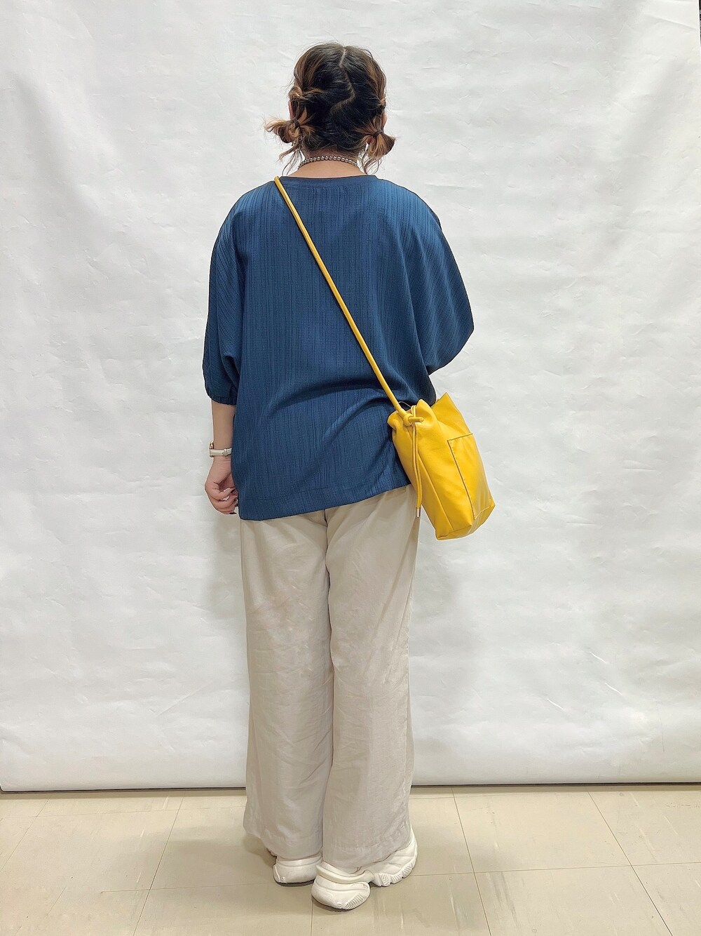 ブルー系のシャツ/ブラウス、ベージュ系のその他パンツ、イエロー系のショルダーバッグを着用したレディースの夏コーディネートの3枚目の写真
