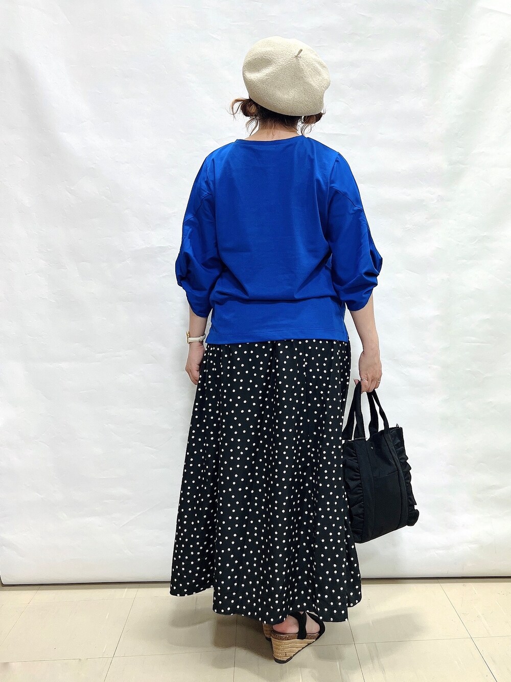 ブルー系のTシャツ/カットソー、ブラック系のスカート、ブラック系のサンダルを着用したレディースの夏コーディネートの3枚目の写真