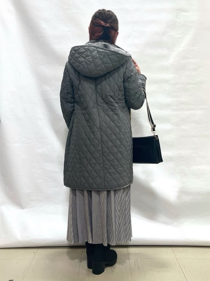 グレー系のその他アウター、グレー系のニット/セーター、グレー系のスカートを着用したレディースの冬コーディネートの3枚目の写真