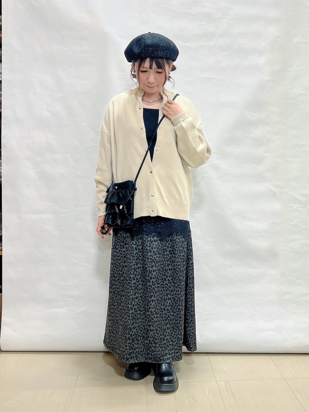 ベージュ系のカーディガン/ボレロ、ブラック系のタンクトップ、グレー系のスカートを着用したレディースの秋コーディネートの4枚目の写真