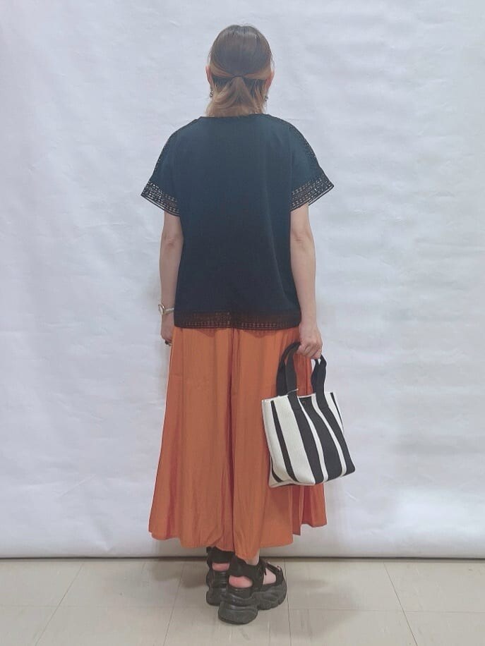 ブラック系のTシャツ/カットソー、オレンジ系のその他パンツ、ブラック系のトートバッグを着用したレディースの夏コーディネートの3枚目の写真