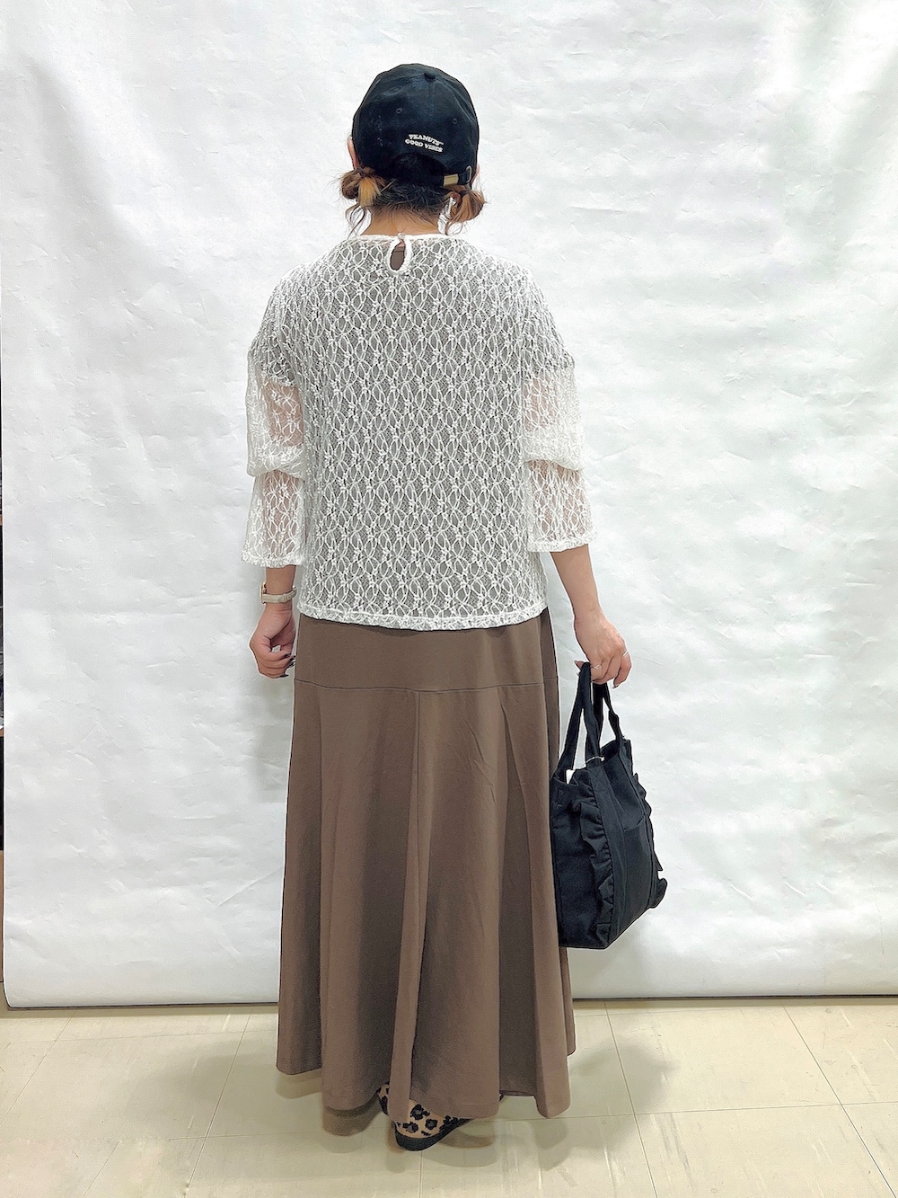 ブラウン系のワンピース、ホワイト系のTシャツ/カットソー、ブラウン系のパンプスを着用したレディースの夏コーディネートの3枚目の写真