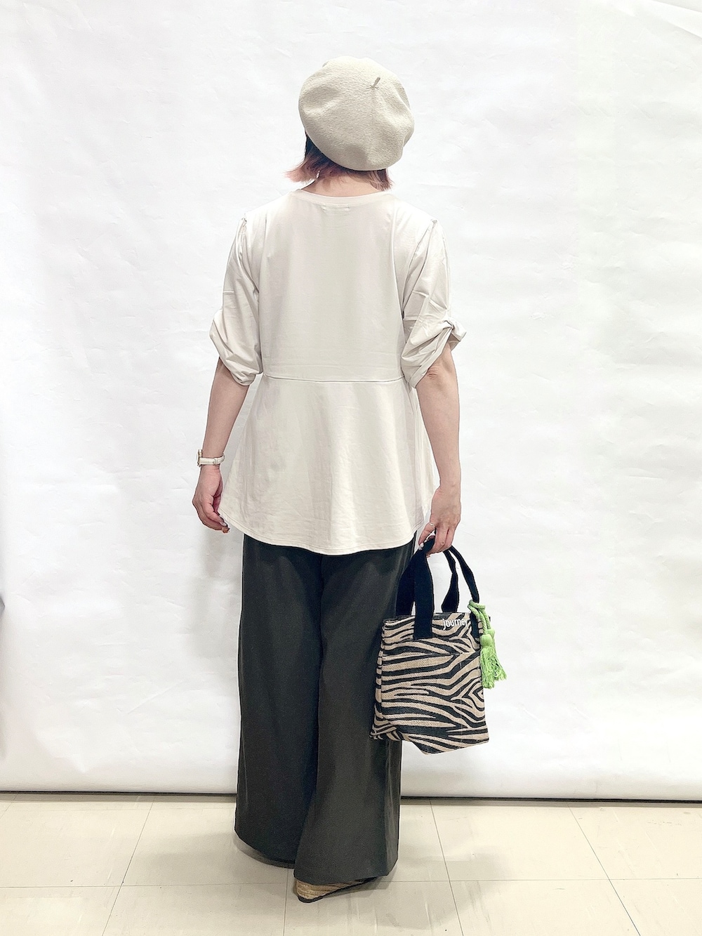 ベージュ系のTシャツ/カットソー、ブラウン系のその他パンツ、ブラック系のサンダルを着用したレディースの春コーディネートの3枚目の写真
