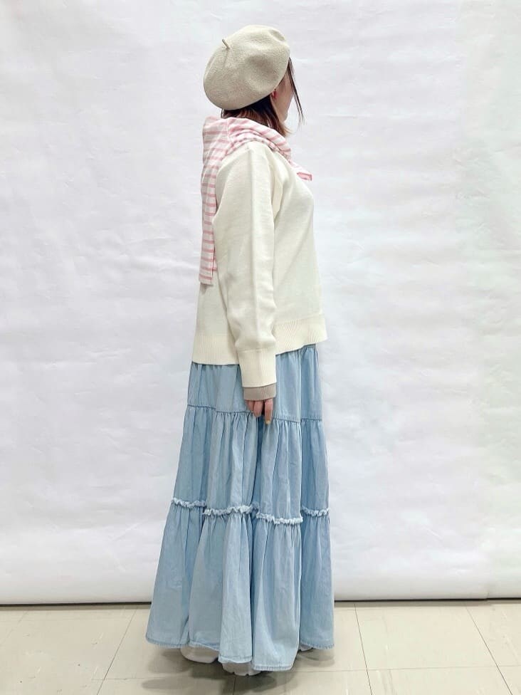 ホワイト系のニット/セーター、ピンク系のTシャツ/カットソー、ブルー系のデニムスカートを着用したレディースの春コーディネートの2枚目の写真