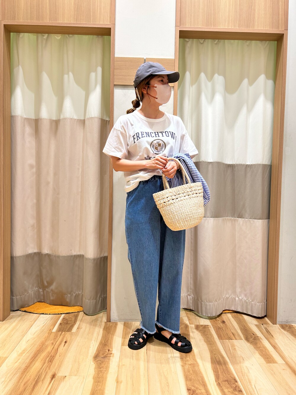 ホワイト系のTシャツ/カットソー、ブルー系のデニムパンツ、ブルー系のキャップを着用したレディースの夏コーディネートの2枚目の写真
