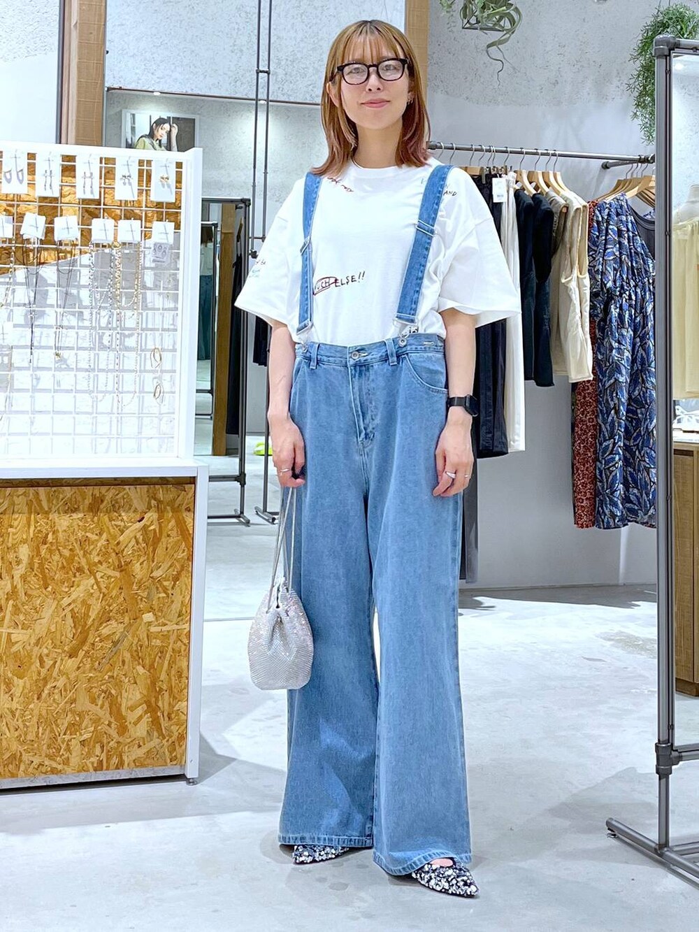 シルバー系のショルダーバッグ、シルバー系のパンプス、ホワイト系のTシャツ/カットソーを着用したレディースの夏コーディネートの2枚目の写真