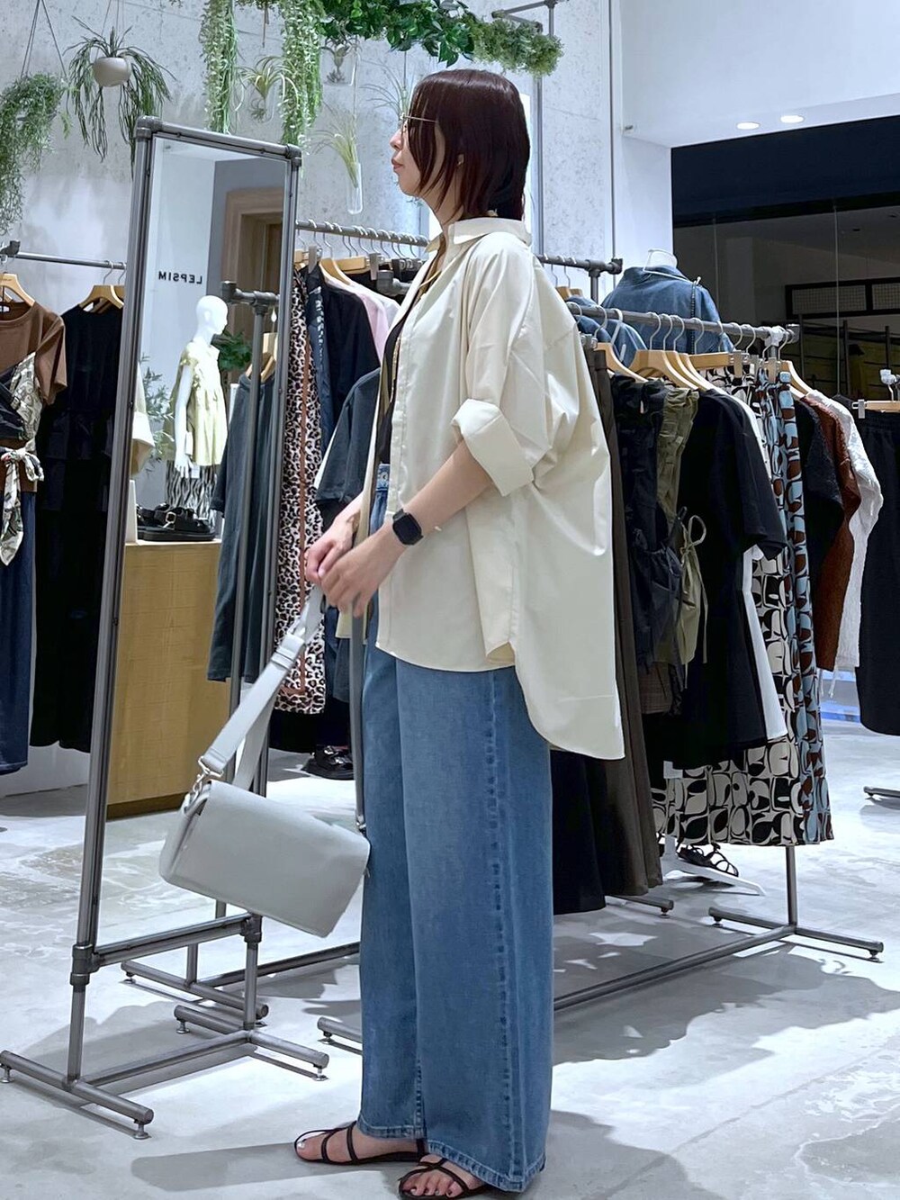 ブラック系のタンクトップ、ブラック系のサンダル、ブルー系のデニムパンツを着用したレディースの夏コーディネートの3枚目の写真