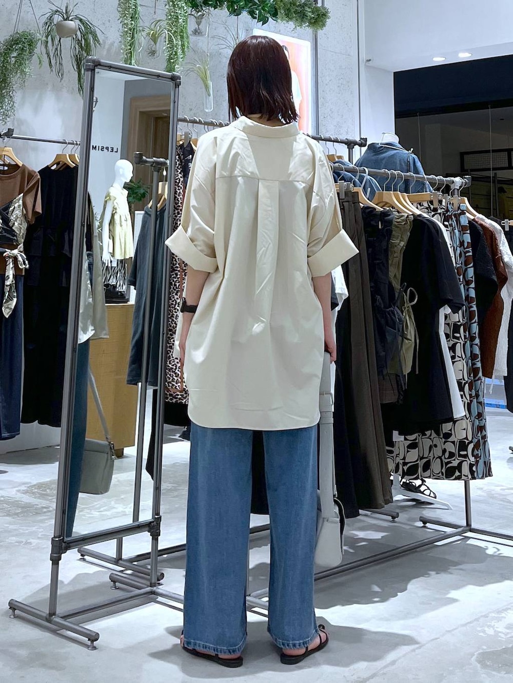 ブラック系のタンクトップ、ブラック系のサンダル、ブルー系のデニムパンツを着用したレディースの夏コーディネートの4枚目の写真