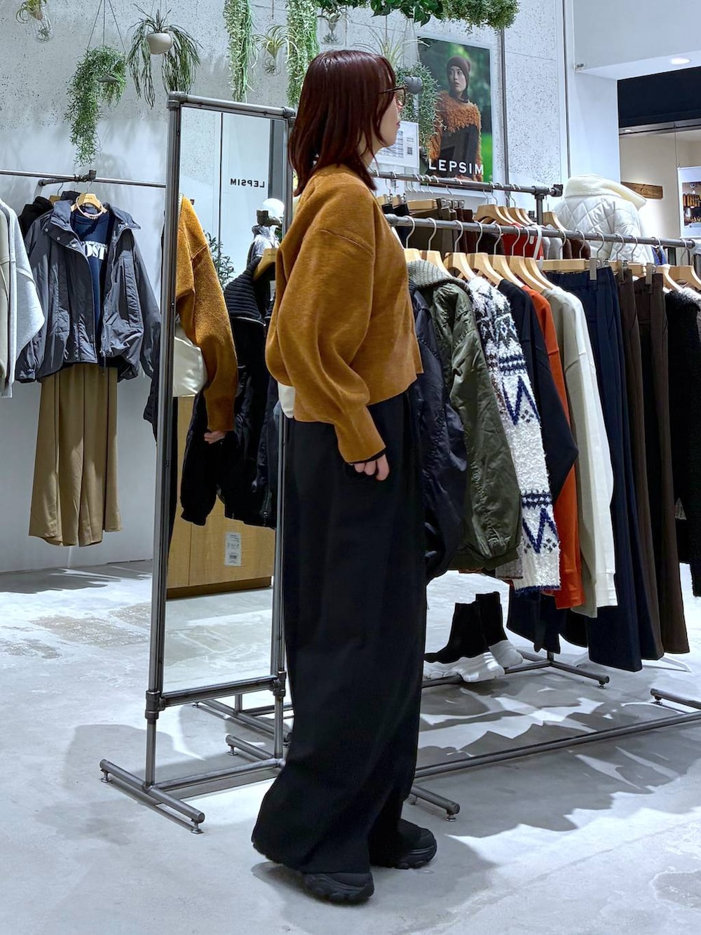 ブラック系のその他パンツ、ブラック系のニット/セーター、ブラック系のスニーカーを着用したレディースの秋コーディネートの3枚目の写真