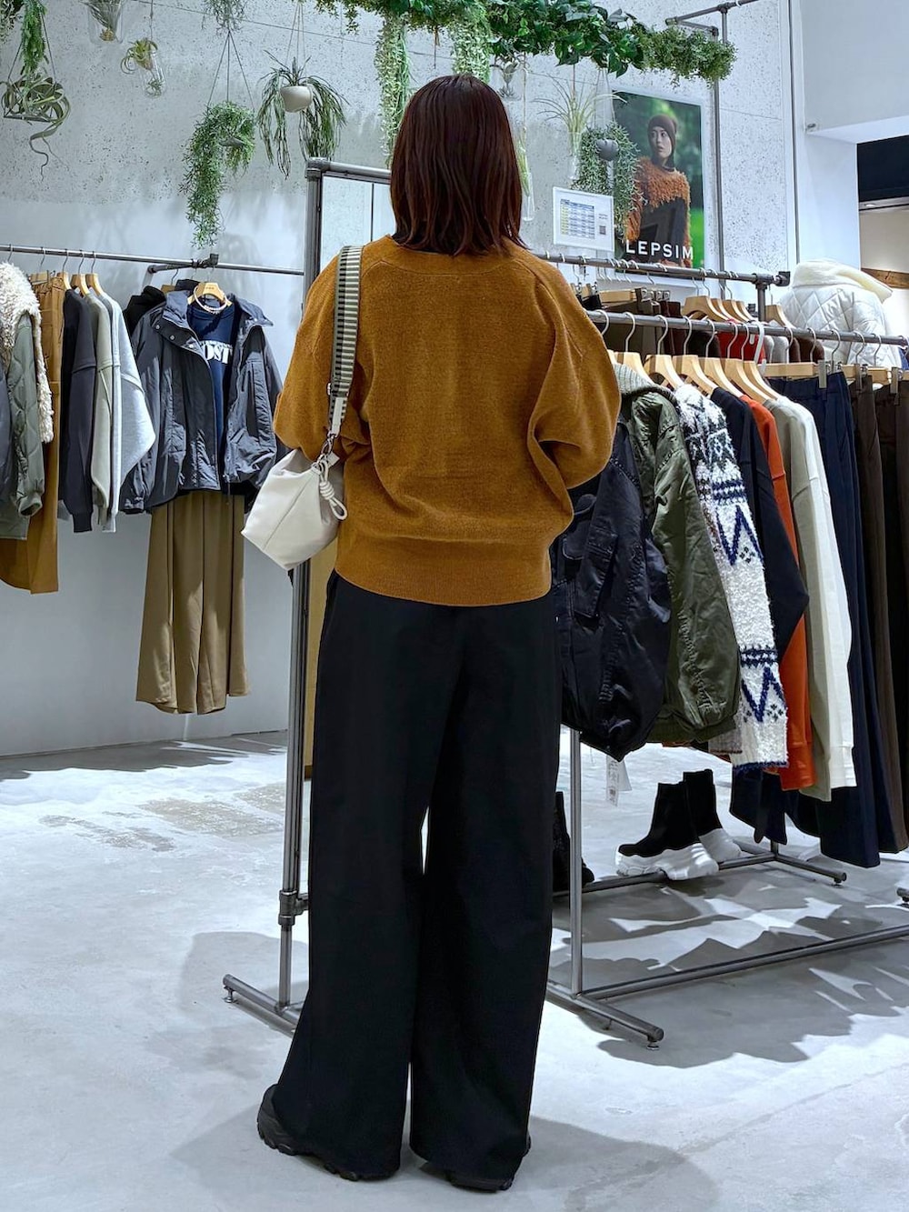 ブラック系のその他パンツ、ブラック系のニット/セーター、ブラック系のスニーカーを着用したレディースの秋コーディネートの4枚目の写真