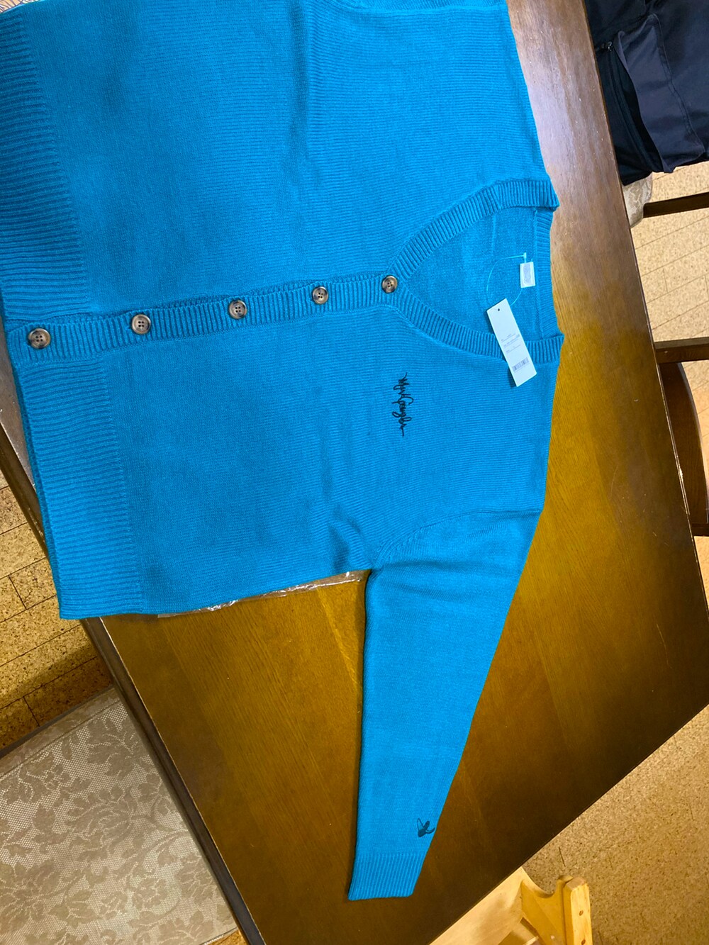 ブルー系のニット/セーター、ブラック系のチノパンツ、ベージュ系のTシャツ/カットソーを着用したメンズの冬コーディネートの3枚目の写真