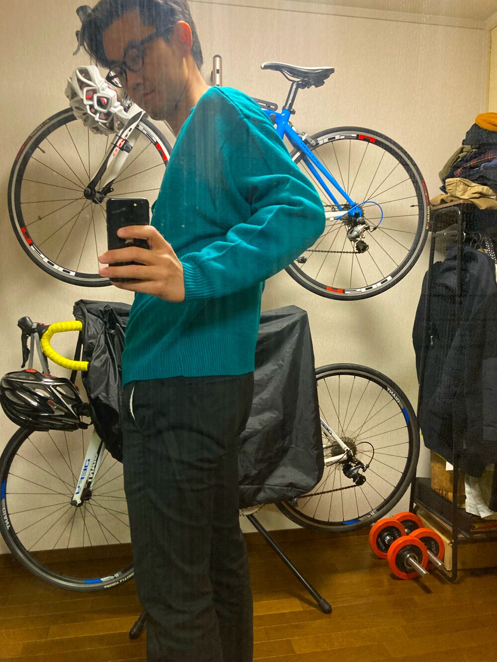 ブルー系のニット/セーター、ブラック系のチノパンツ、ベージュ系のTシャツ/カットソーを着用したメンズの冬コーディネートの2枚目の写真