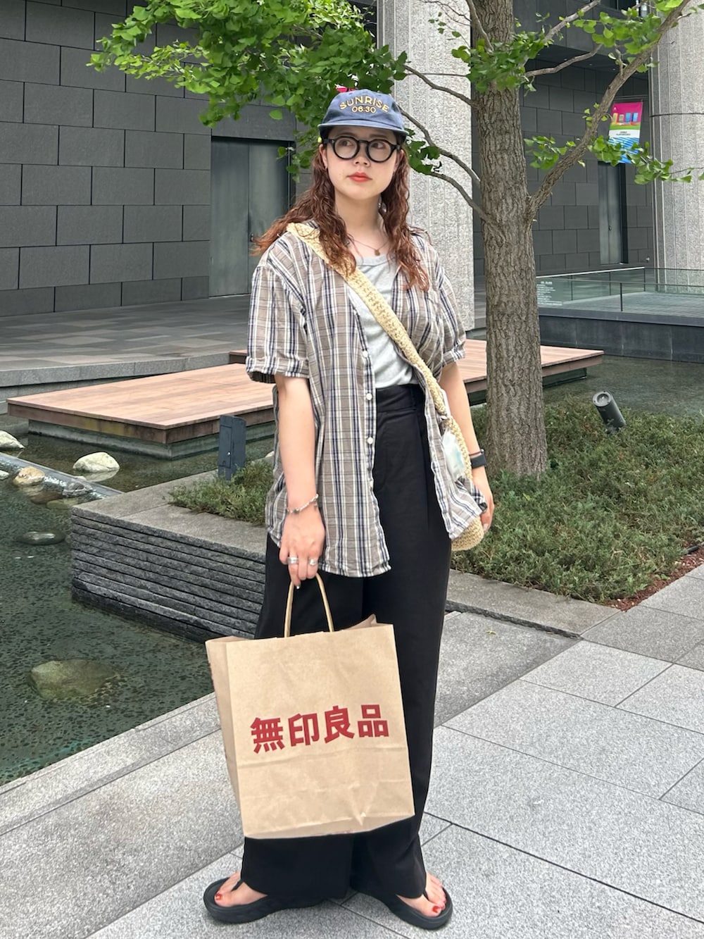 ベージュ系のショルダーバッグ、ブラウン系のシャツ/ブラウス、ブラック系のスラックスを着用したレディースの夏コーディネートの2枚目の写真