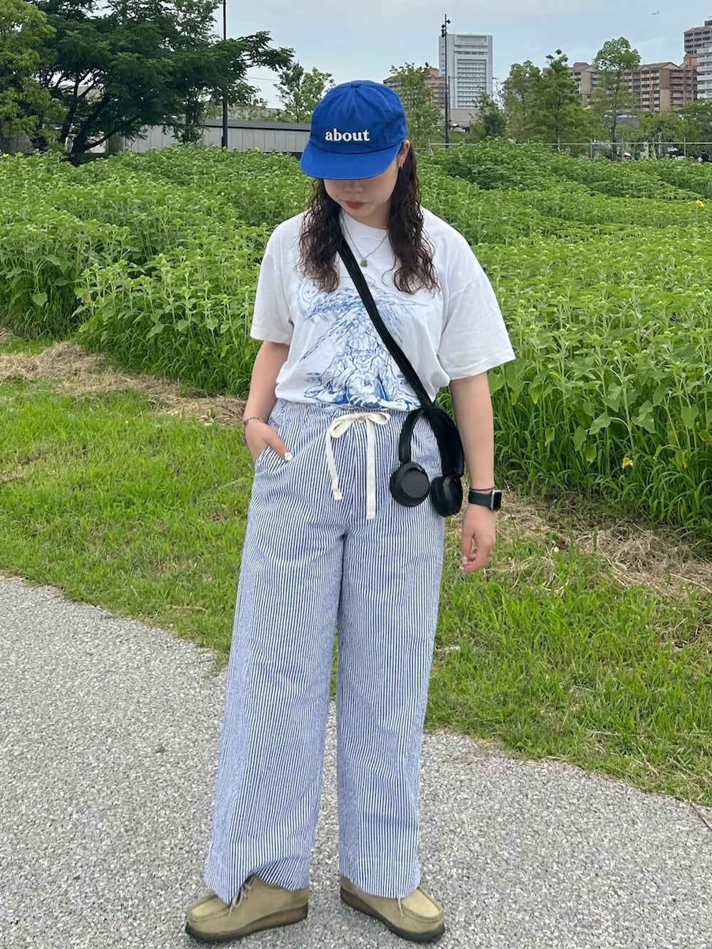 ブルー系のスラックス、ベージュ系のモカシン/デッキシューズ、ホワイト系のTシャツ/カットソーを着用したレディースの夏コーディネートの3枚目の写真
