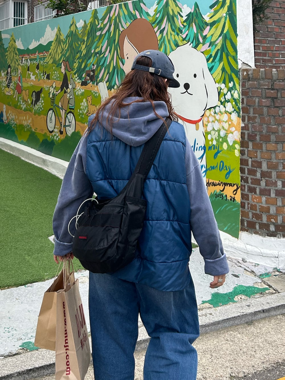 ブルー系のデニムパンツ、ブラック系のスリッポン、ブルー系のパーカーを着用したレディースの秋コーディネートの2枚目の写真