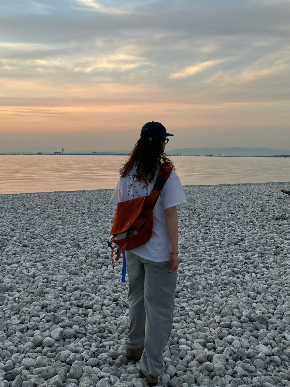 グレー系のスウェットパンツ、ベージュ系のモカシン/デッキシューズ、ホワイト系のTシャツ/カットソーを着用したレディースの夏コーディネートの2枚目の写真