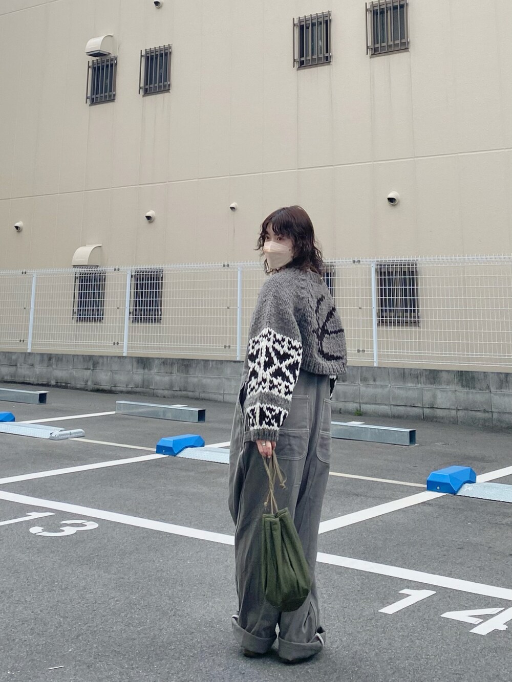 グリーン系のハンドバッグ、グレー系のサロペット/オーバーオール、ベージュ系のモカシン/デッキシューズを着用したレディースの冬コーディネートの2枚目の写真