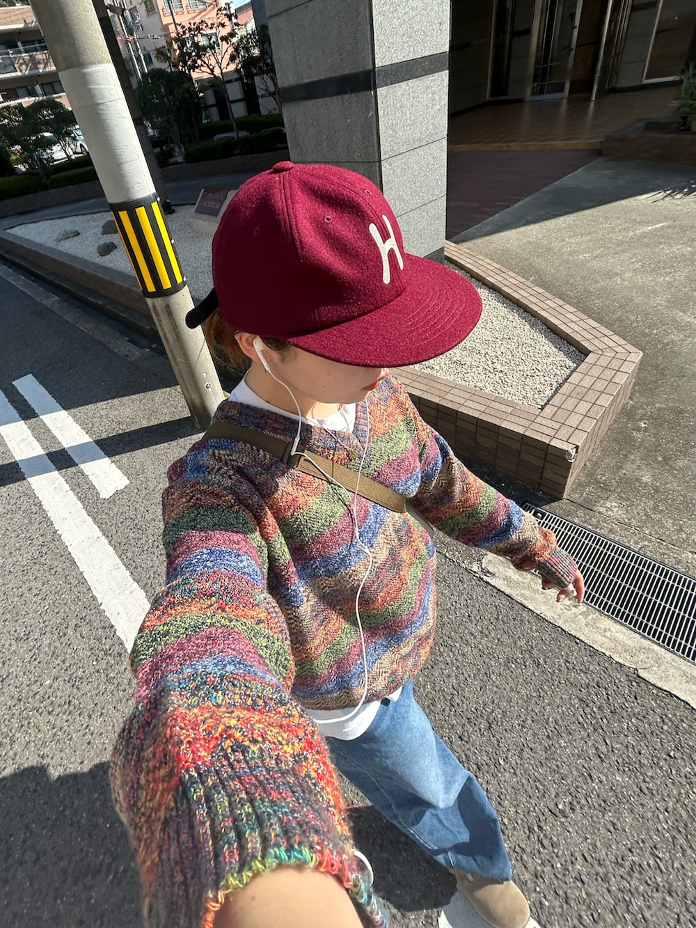 ブルー系のデニムパンツ、グレー系のサンダル、その他のニット/セーターを着用したレディースの秋コーディネートの2枚目の写真