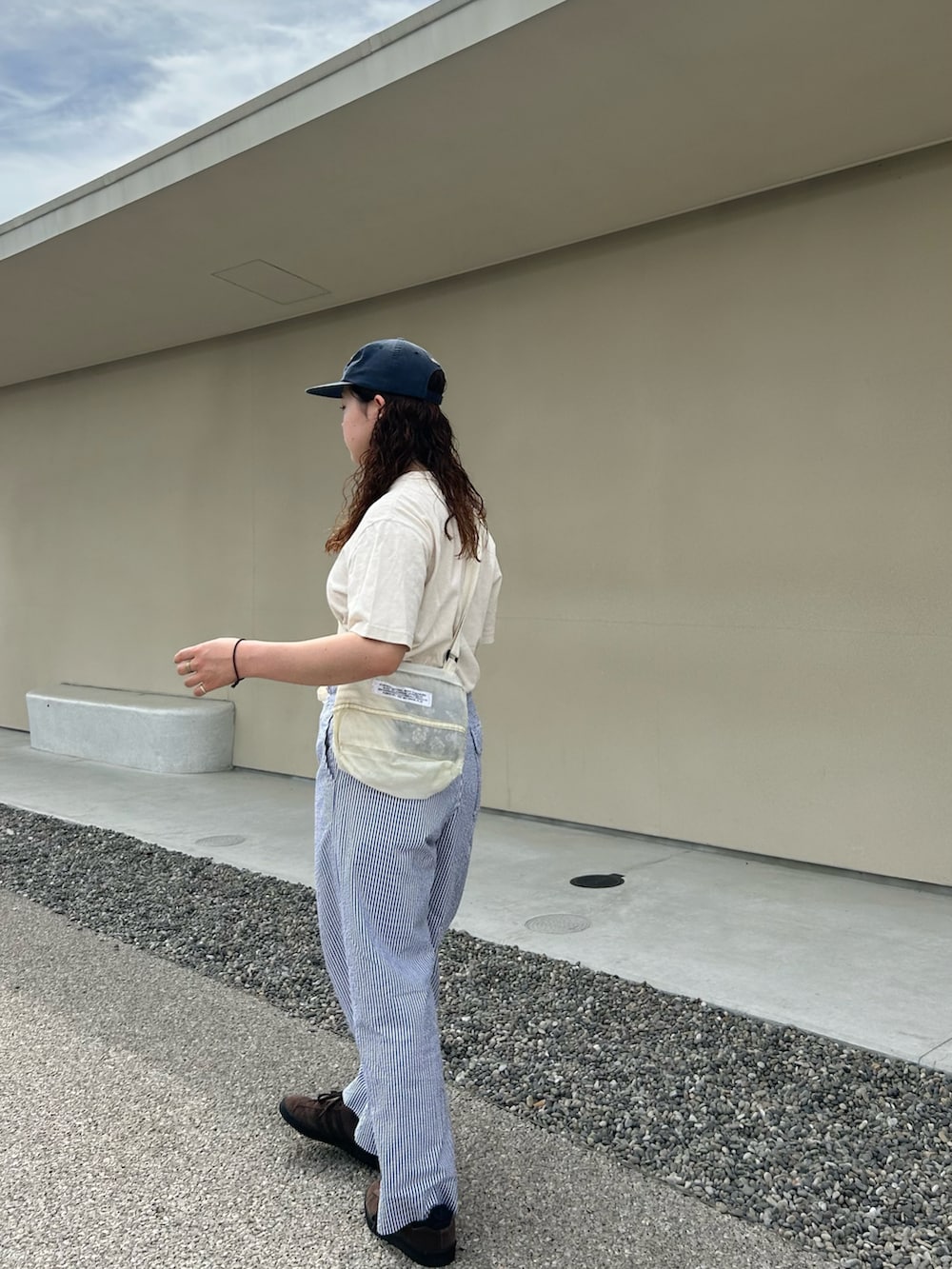 ホワイト系のTシャツ/カットソー、ブルー系のスラックス、ブラウン系のスニーカーを着用したレディースの夏コーディネートの2枚目の写真