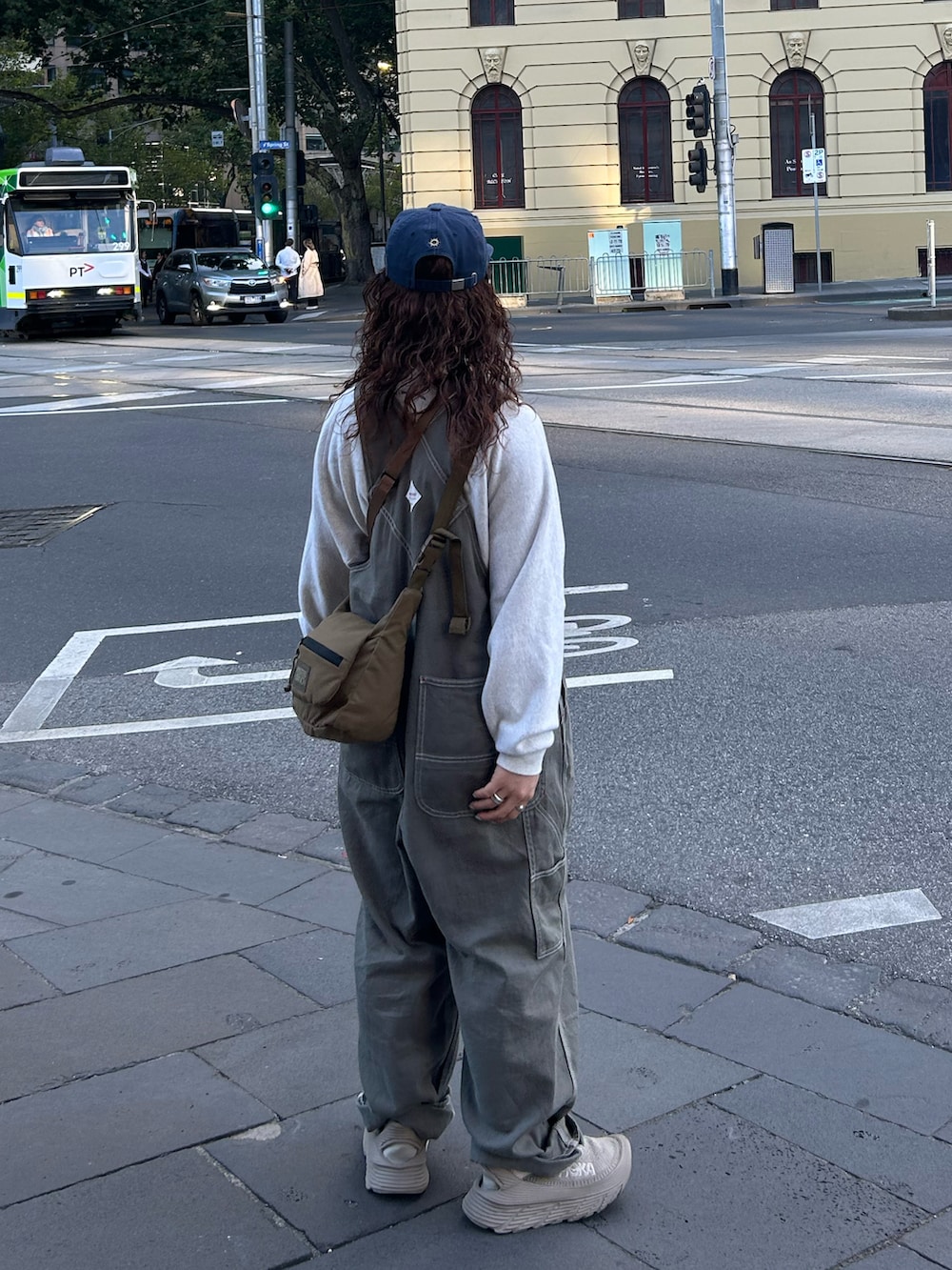 グレー系のサロペット/オーバーオール、ベージュ系のスニーカー、ベージュ系のスウェットを着用したレディースの春コーディネートの2枚目の写真