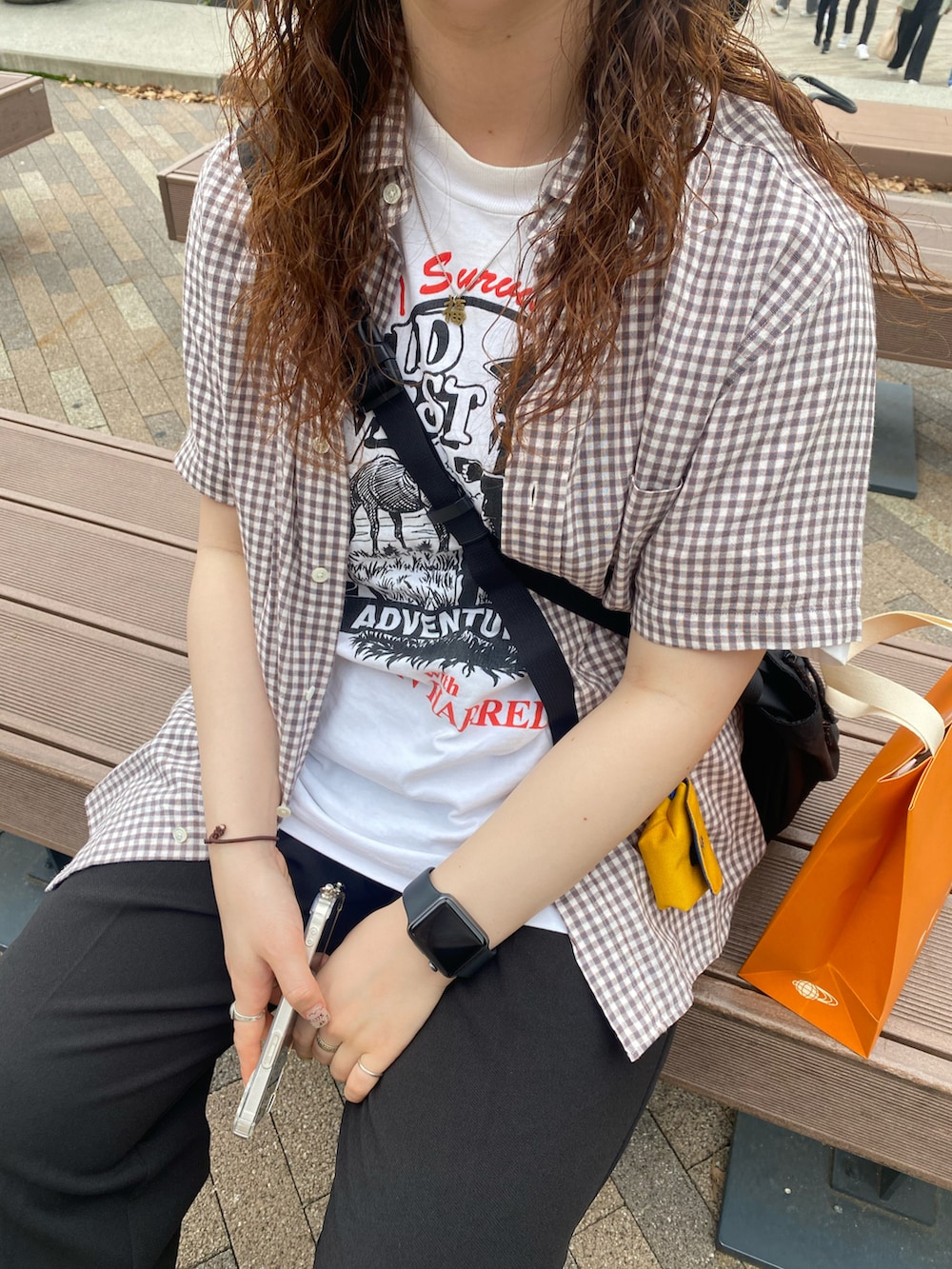 ブラック系のスラックス、ベージュ系のモカシン/デッキシューズ、ブラック系のショルダーバッグを着用したレディースの春コーディネートの2枚目の写真