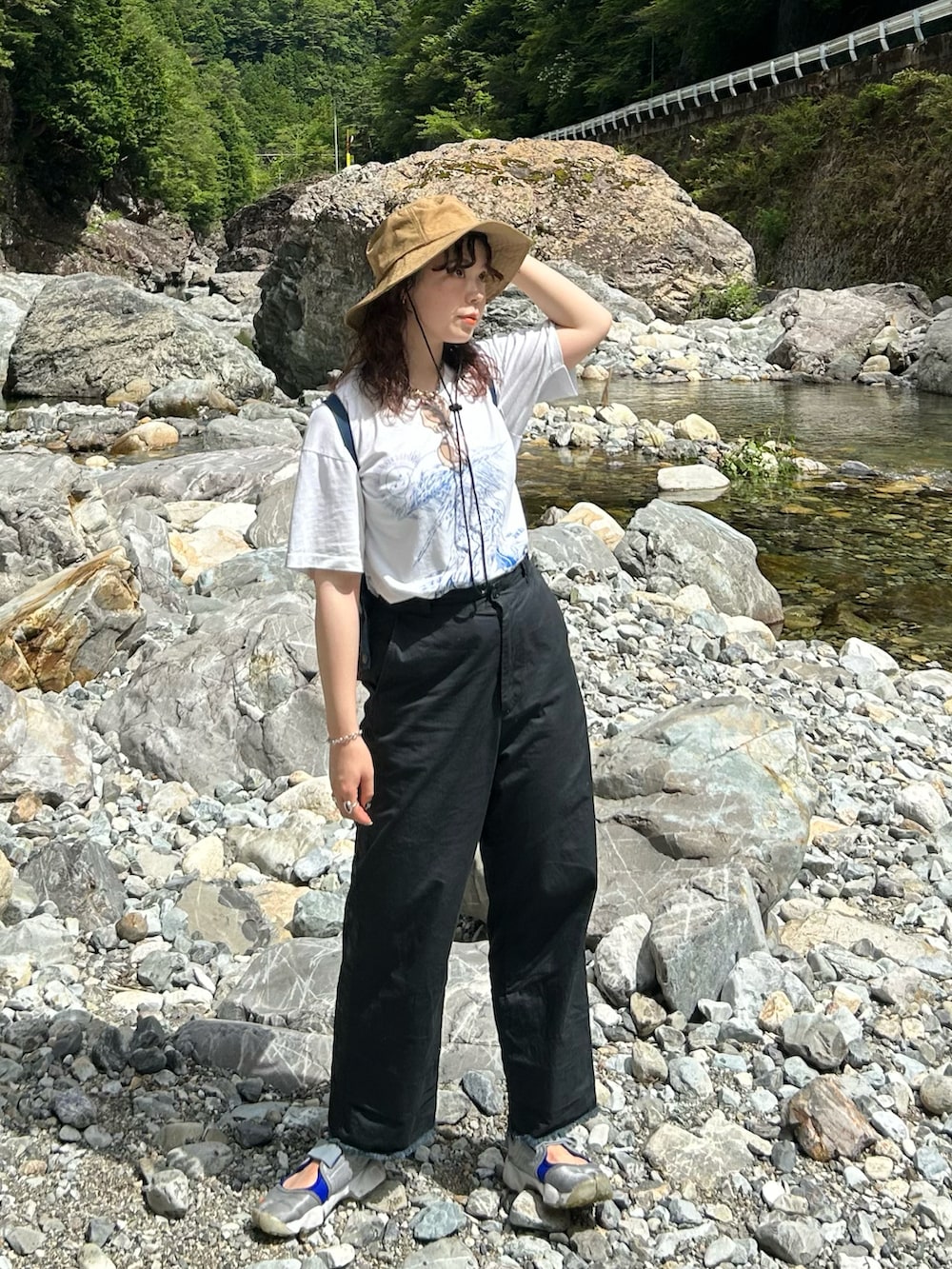 ブラック系のチノパンツ、シルバー系のスニーカー、レッド系のバックパック/リュックを着用したレディースの夏コーディネートの2枚目の写真