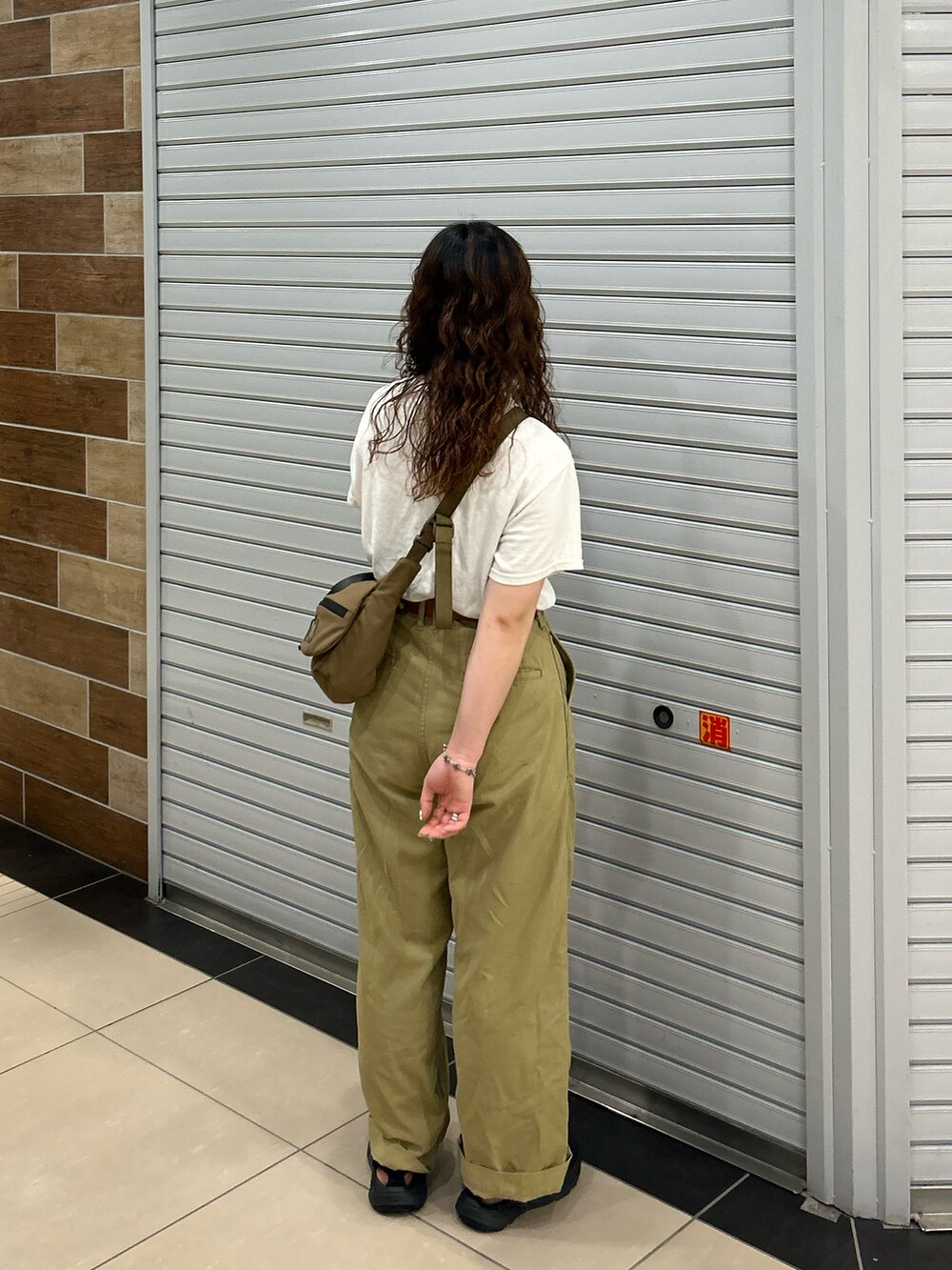 ベージュ系のその他パンツ、ブラック系のショルダーバッグ、ベージュ系のTシャツ/カットソーを着用したレディースの夏コーディネートの3枚目の写真