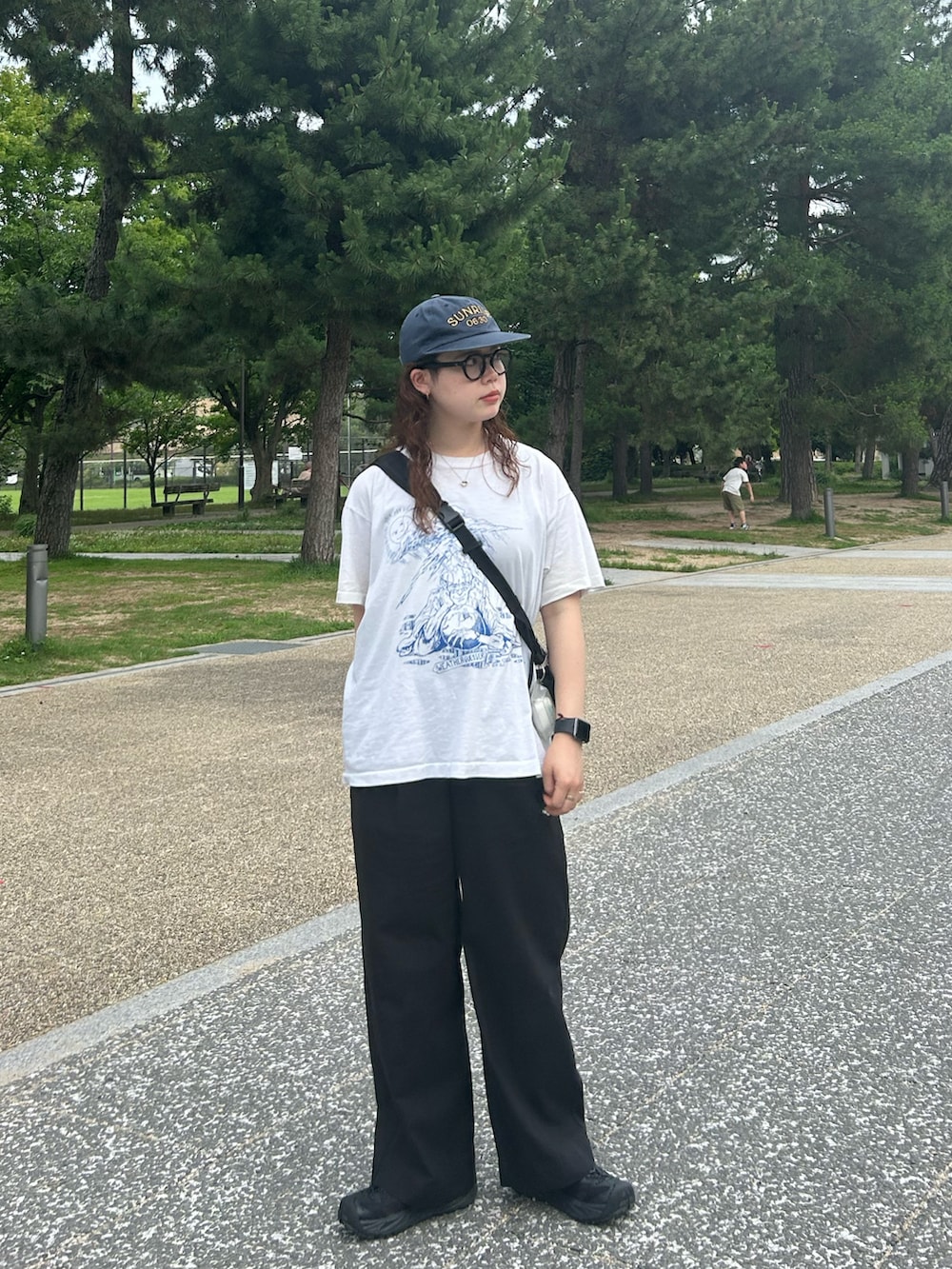 ブラック系のサンダル、ブラック系のスラックス、ホワイト系のTシャツ/カットソーを着用したレディースの夏コーディネートの2枚目の写真