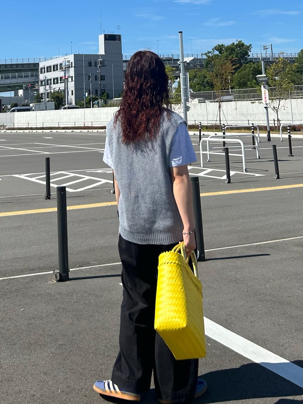 グレー系のベスト、グレー系のTシャツ/カットソー、ブラック系のスラックスを着用したレディースの夏コーディネートの2枚目の写真