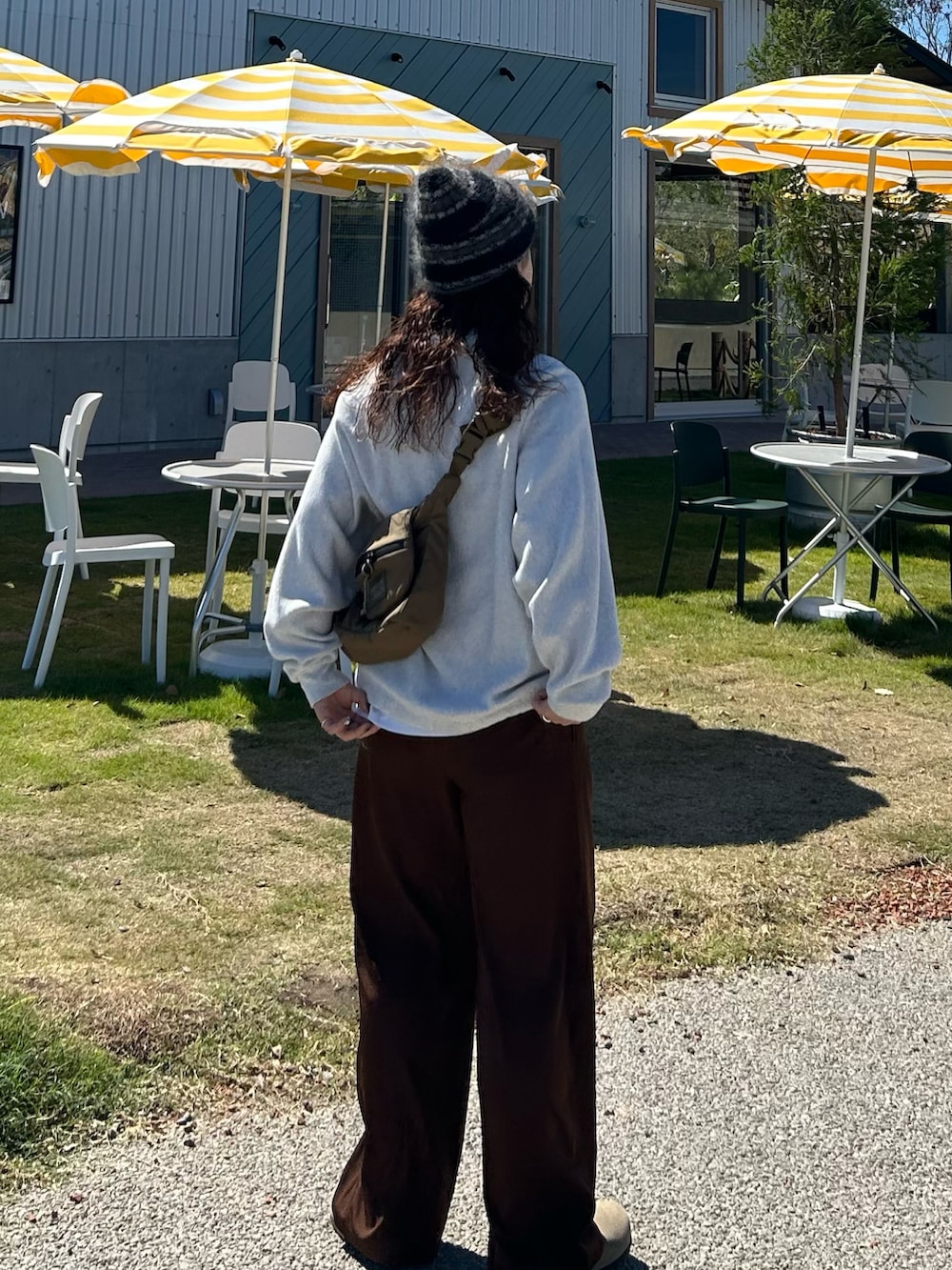 ベージュ系のスウェット、ブラウン系のその他パンツ、グレー系のサンダルを着用したレディースの秋コーディネートの2枚目の写真