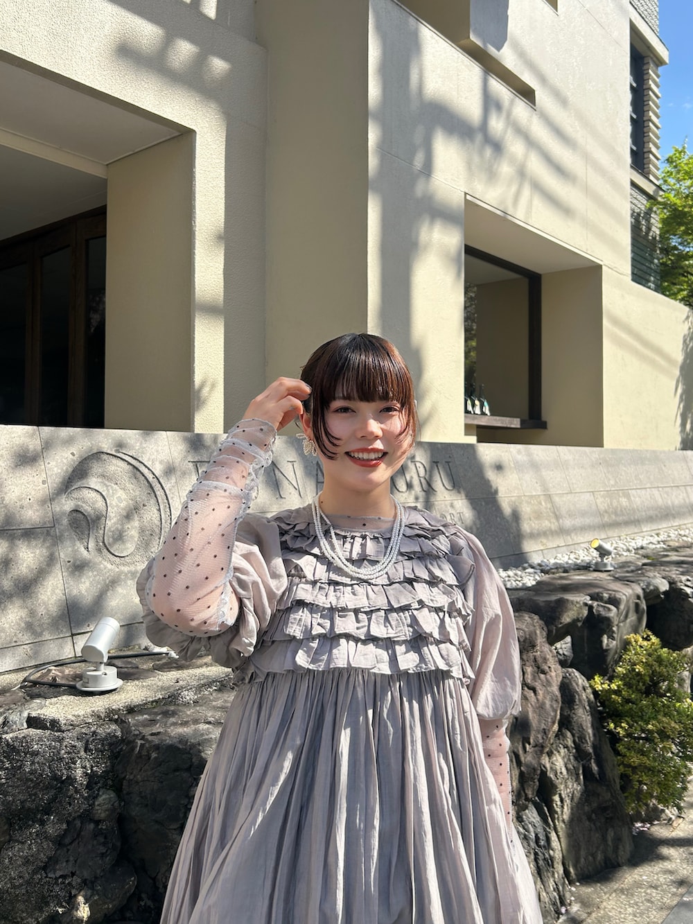 グレー系のワンピース、ブラック系のパンプス、グレー系のTシャツ/カットソーを着用したレディースの夏コーディネートの3枚目の写真